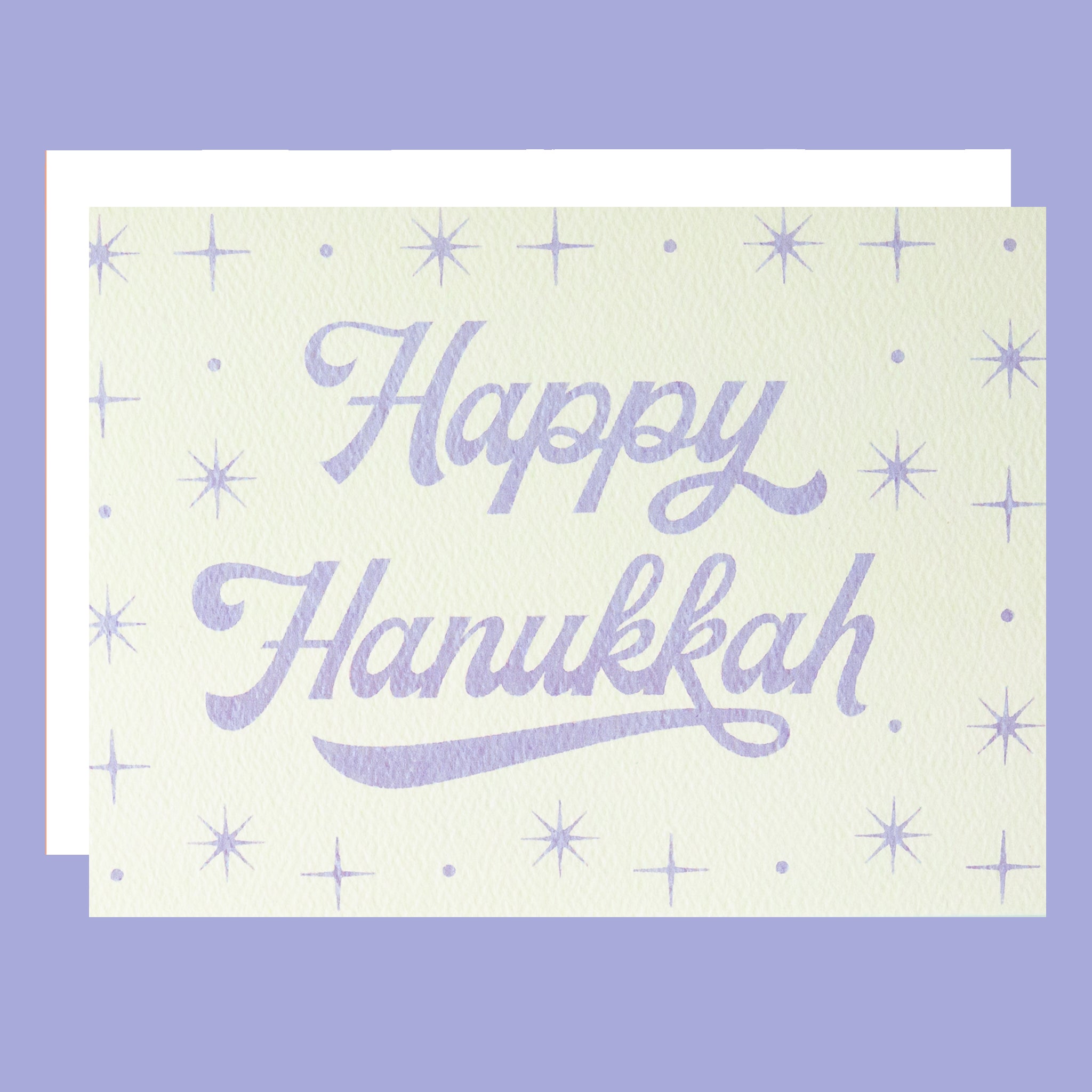 A light blue card that reads, "Happy Hanukkah" with sparkling stars designs around it. 