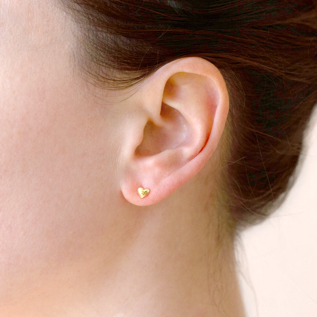 A pair of gold heart stud earrings. 