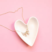 A white, ceramic, heart shaped trinket dish. 