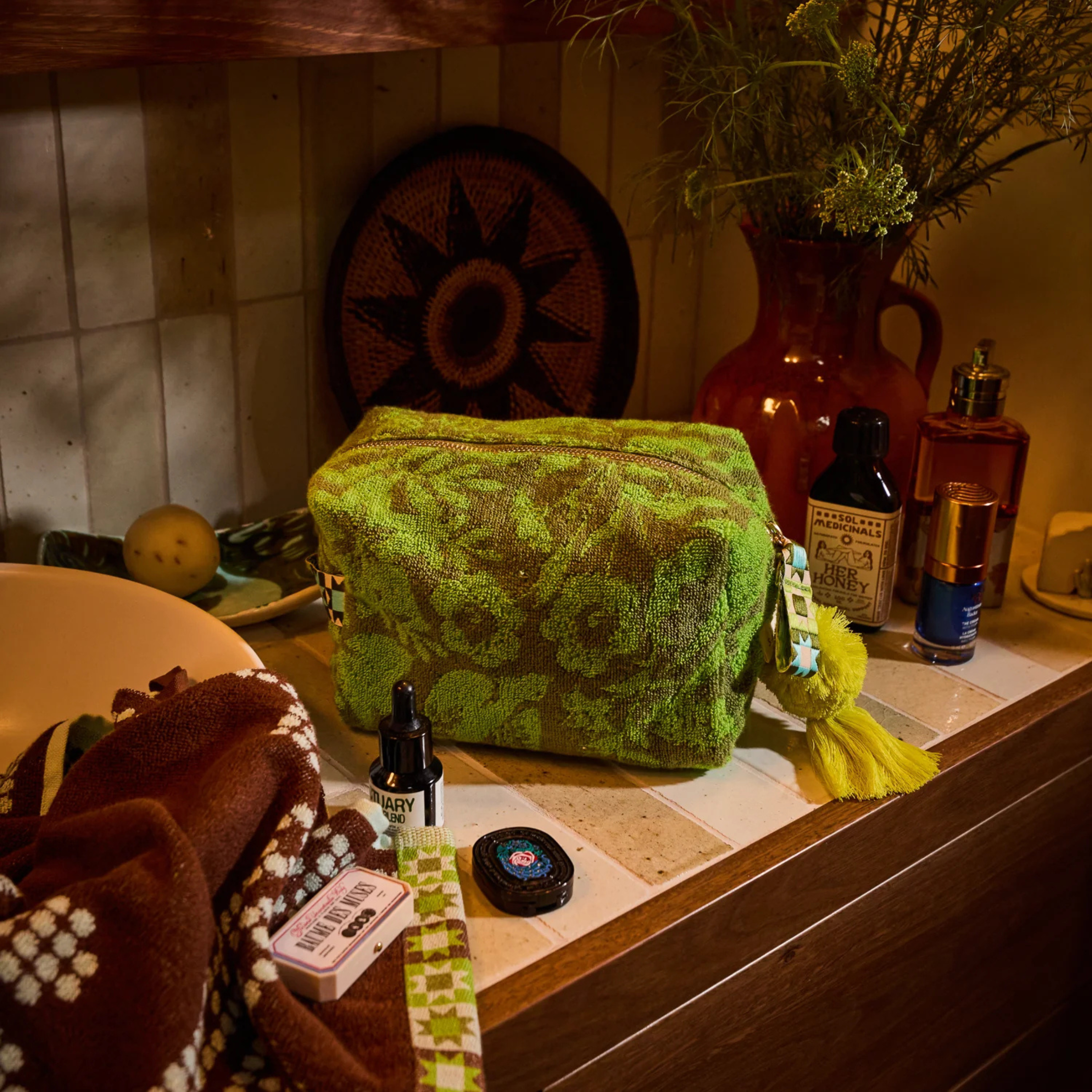 a green floral print terry cloth material pouch. 