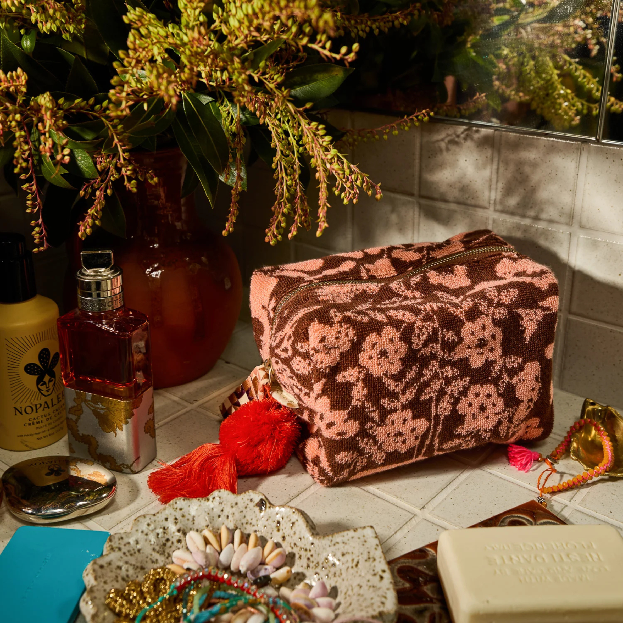a burgundy/brownish and pink floral print terry cloth cosmetic pouch.