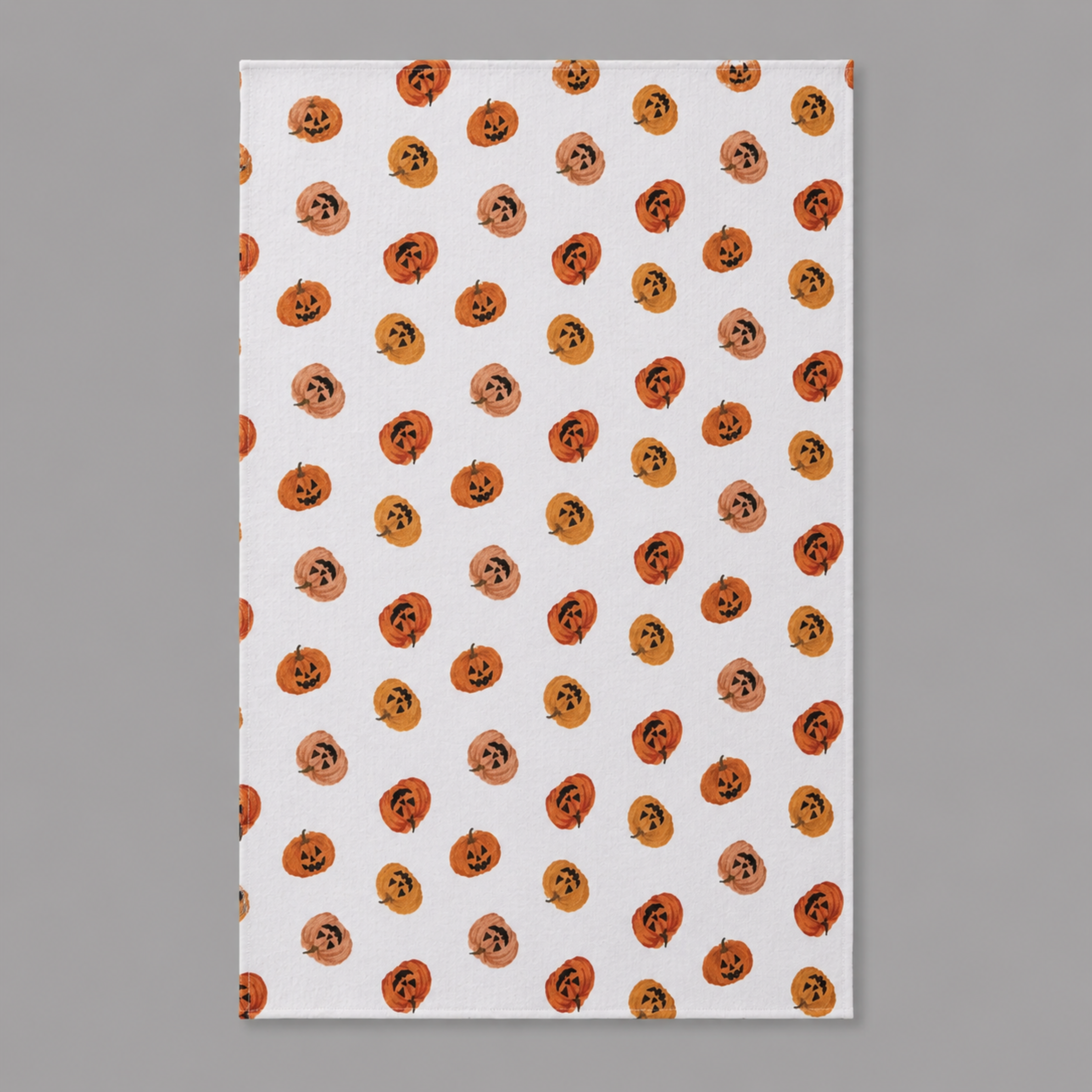 a white towel with an orange pumpkin pattern. 