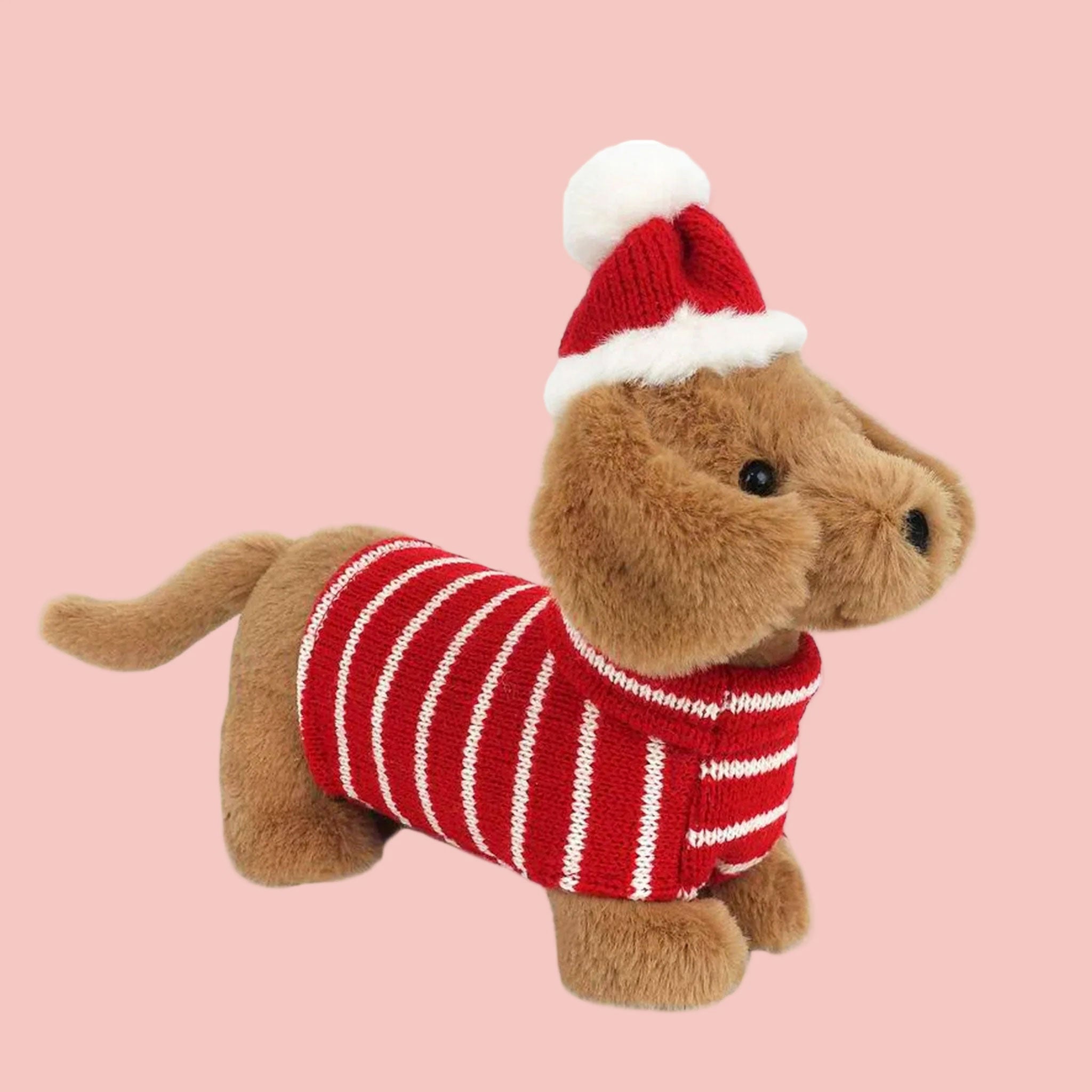 A dachshund puppy stuffed animal dressed in a red and white striped sweater and a red santa hat. 
