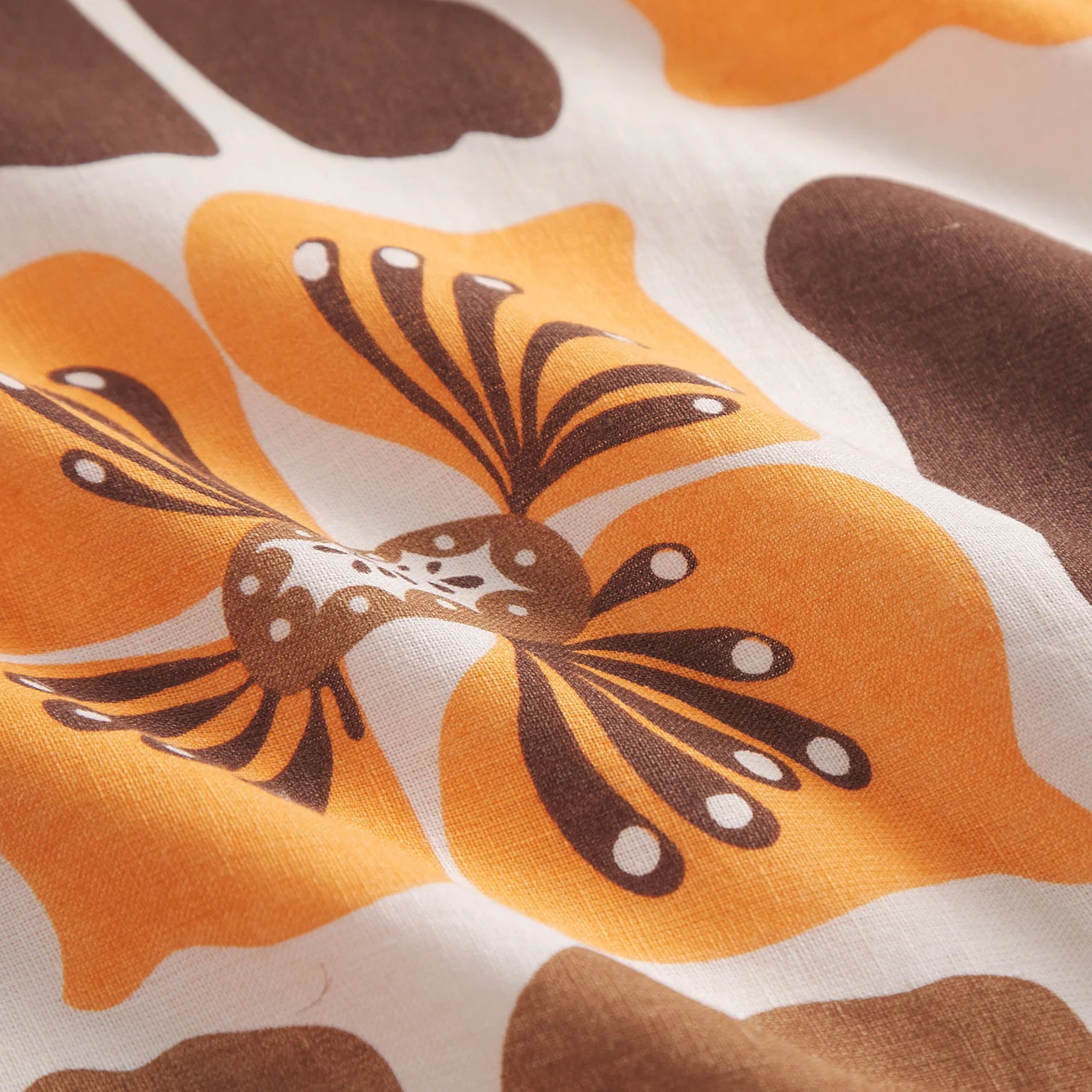 a brown and yellow floral print pillow. 