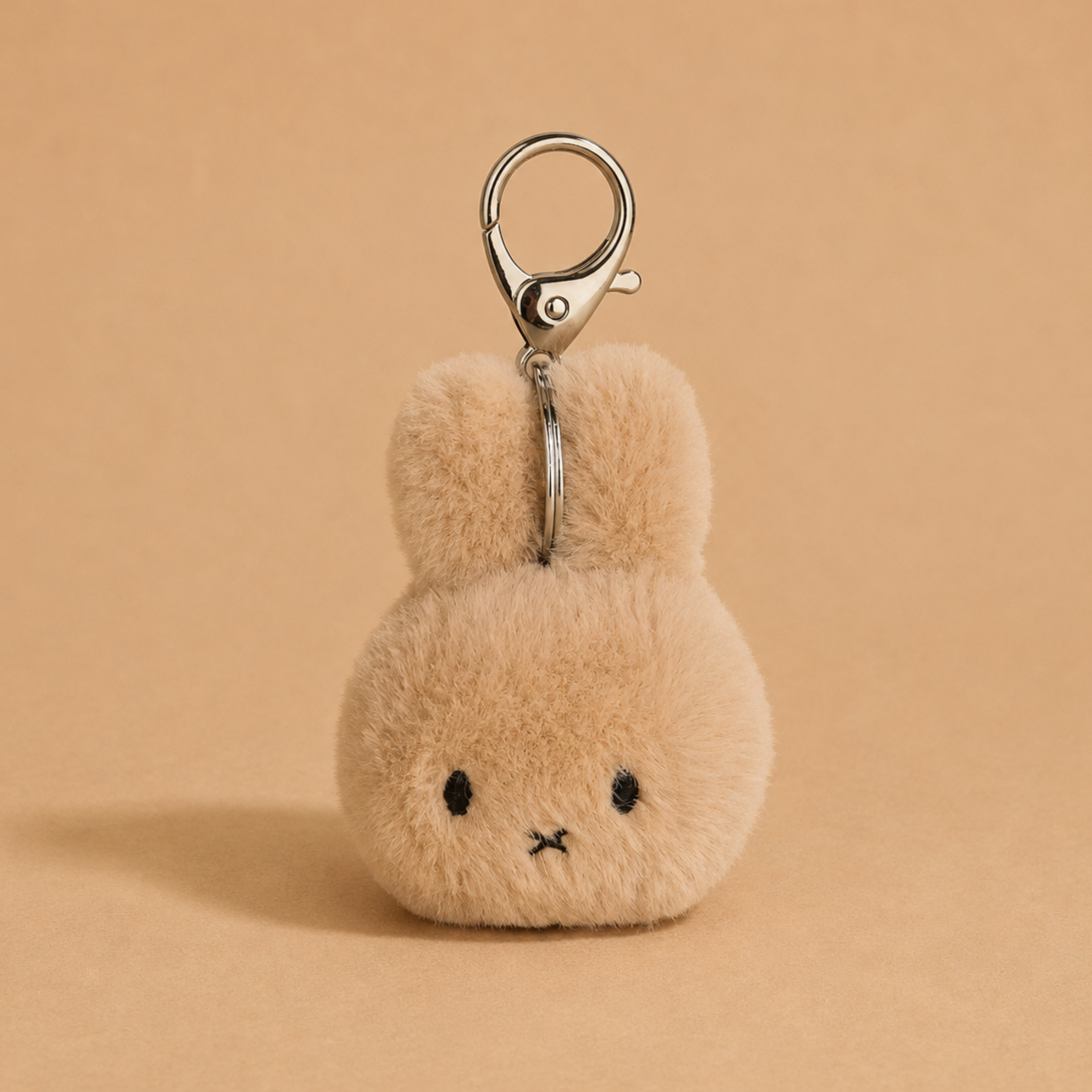 a beige miffy head shaped keychain