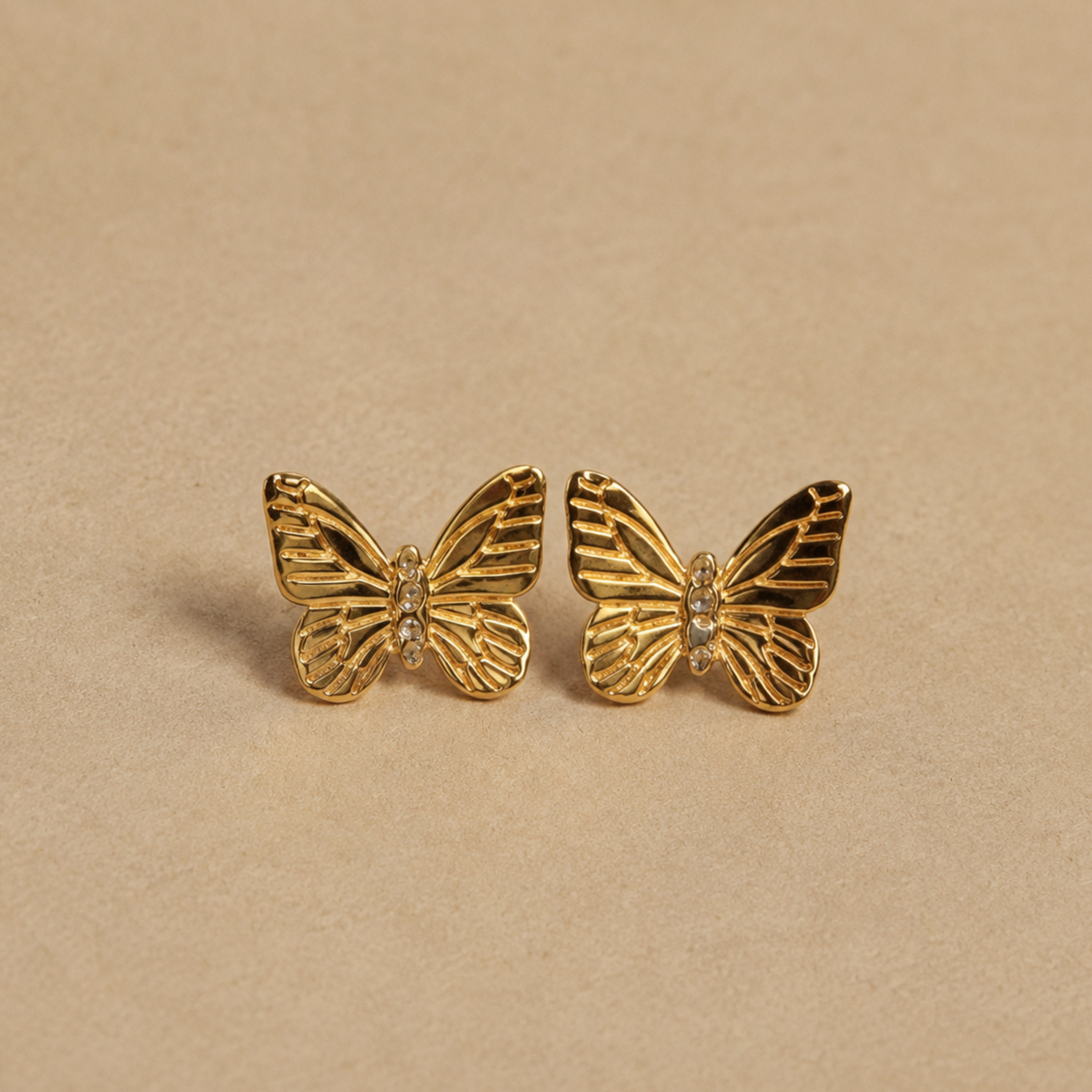 a pair of gold butterfly shaped stud earrings. 