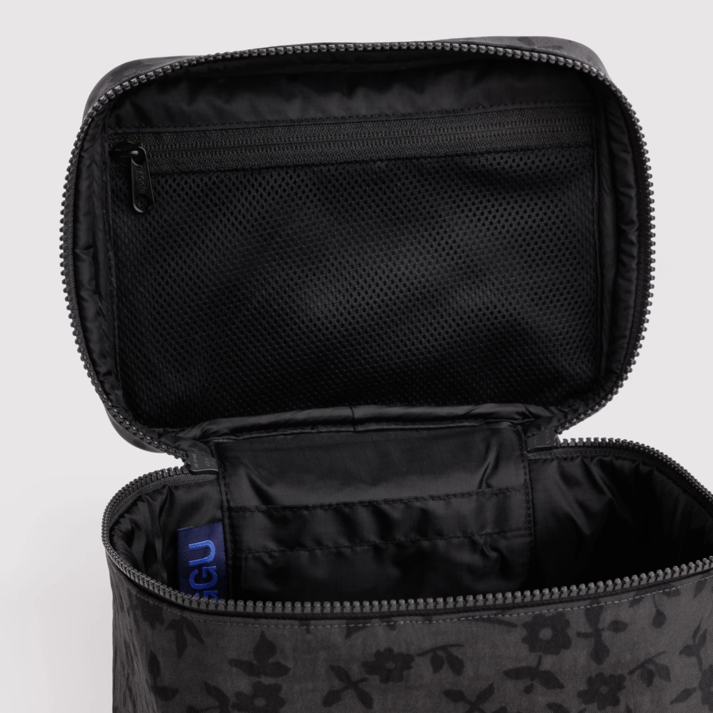 A grey and black floral print cosmetic case. 