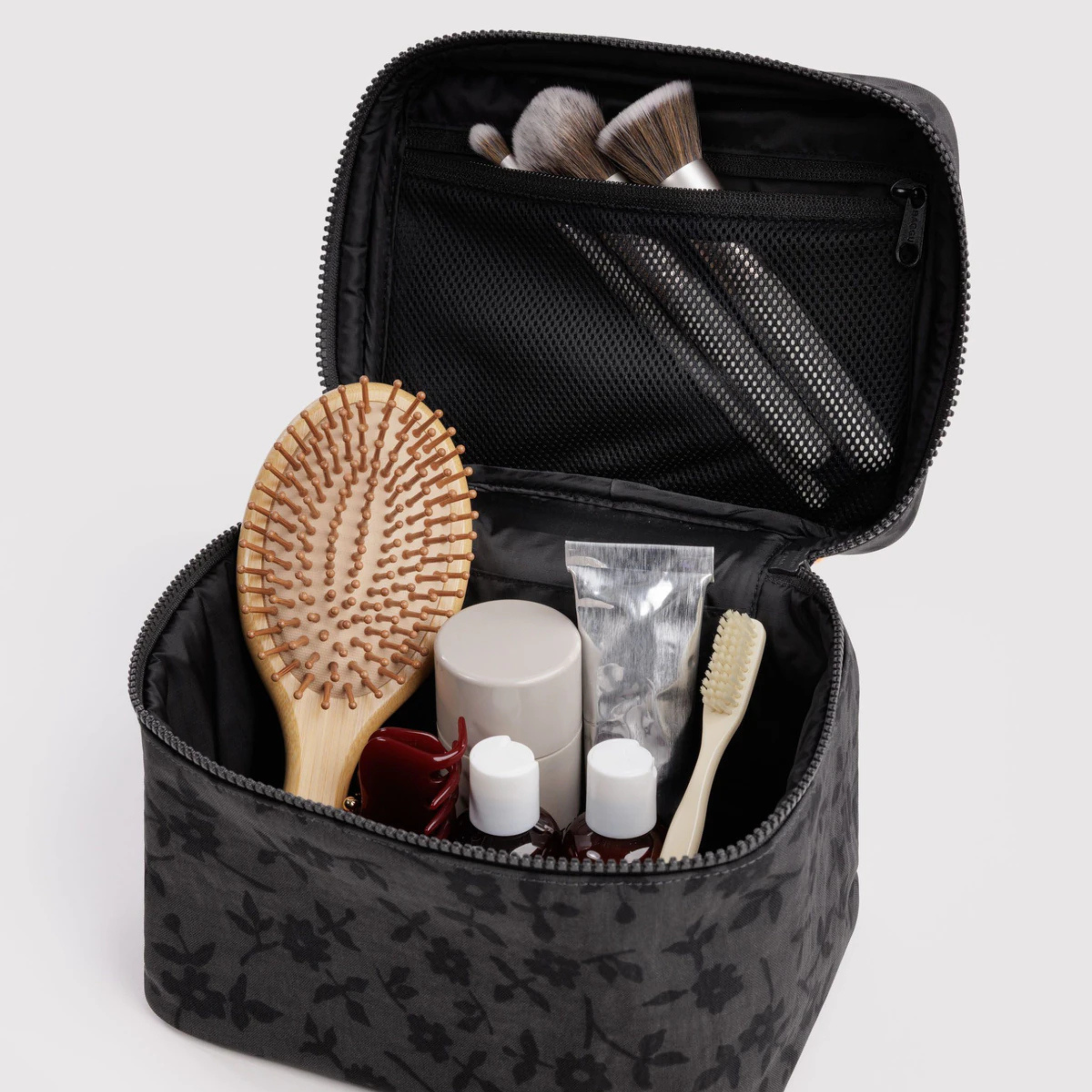 A grey and black floral print cosmetic case. 