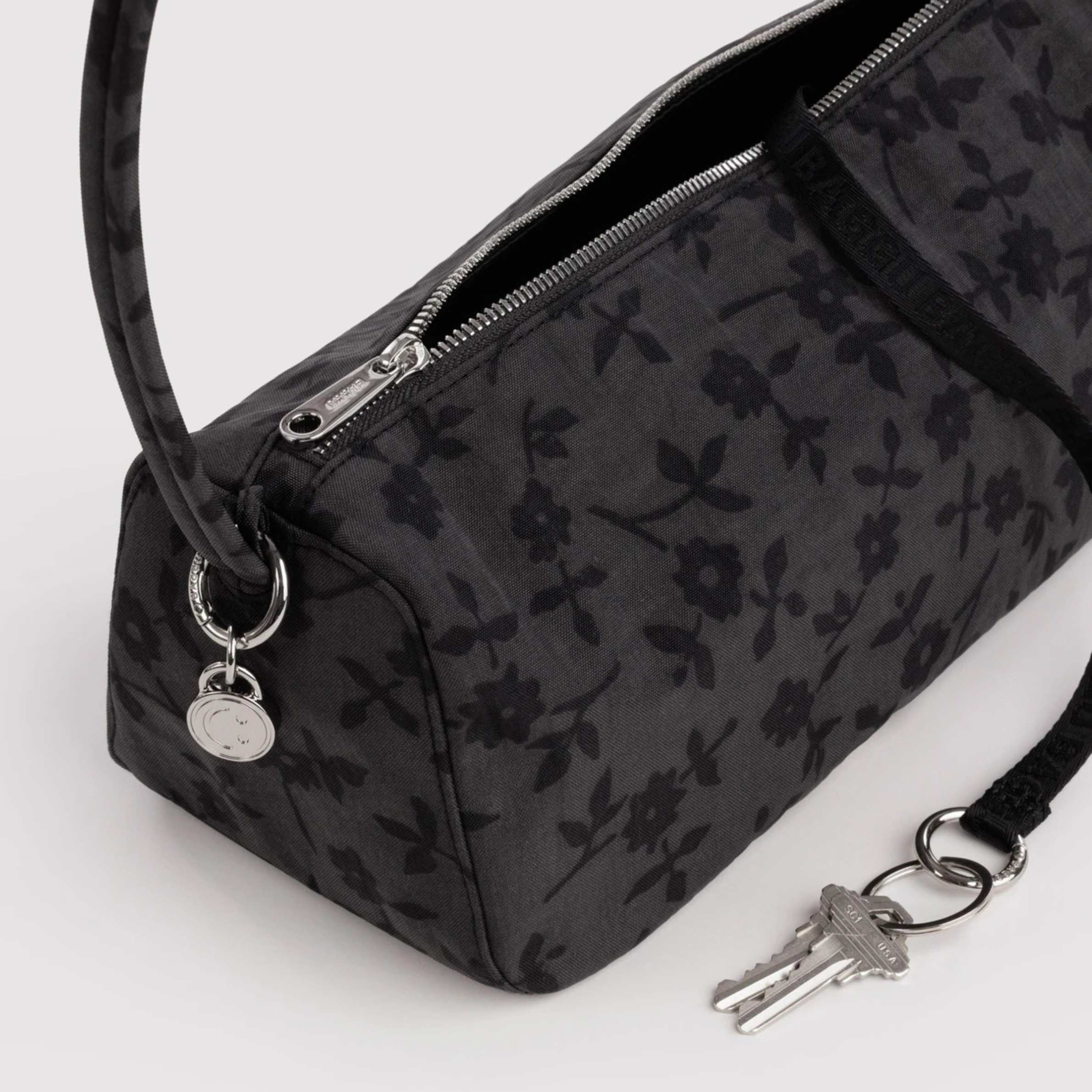 A charcoal shoulder bag with black floral print.