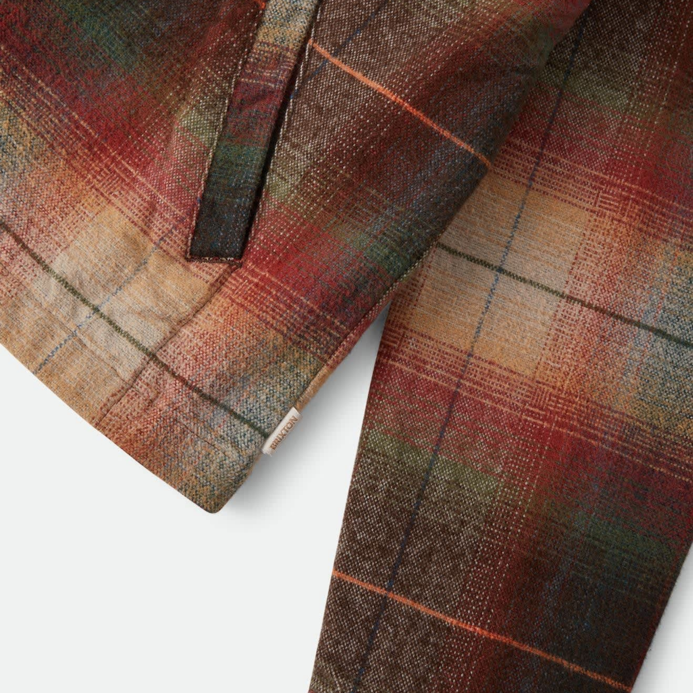 a multi colored zip up mechanics jacket with a brown corduroy collar. 