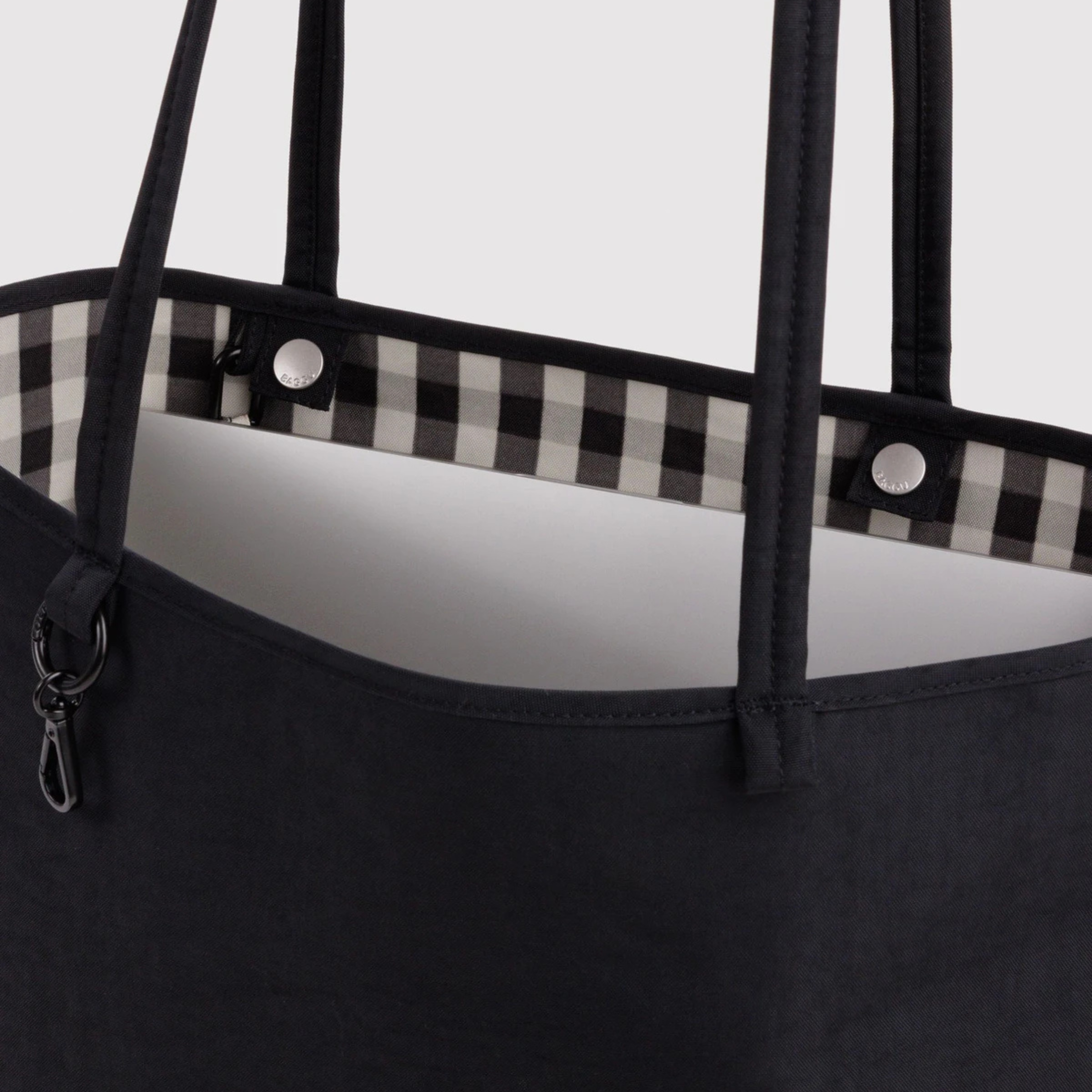 A black and black and white checkered reversible tote bag. 