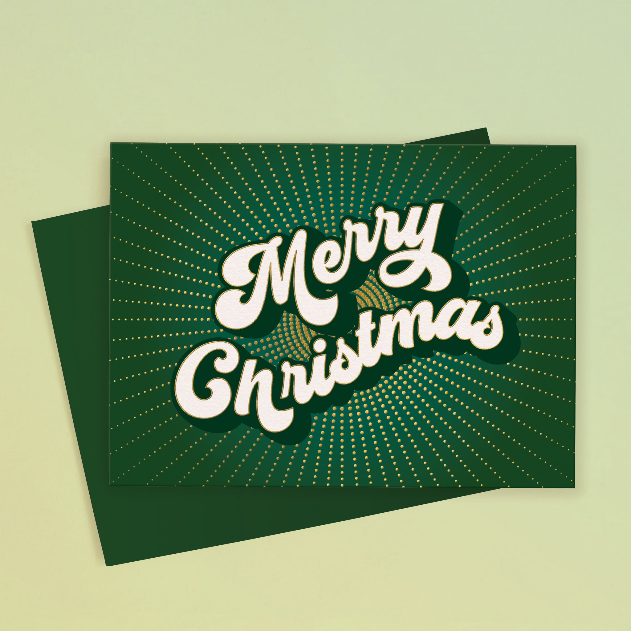 A green card with white text in the center that reads, 'Merry Christmas'. 