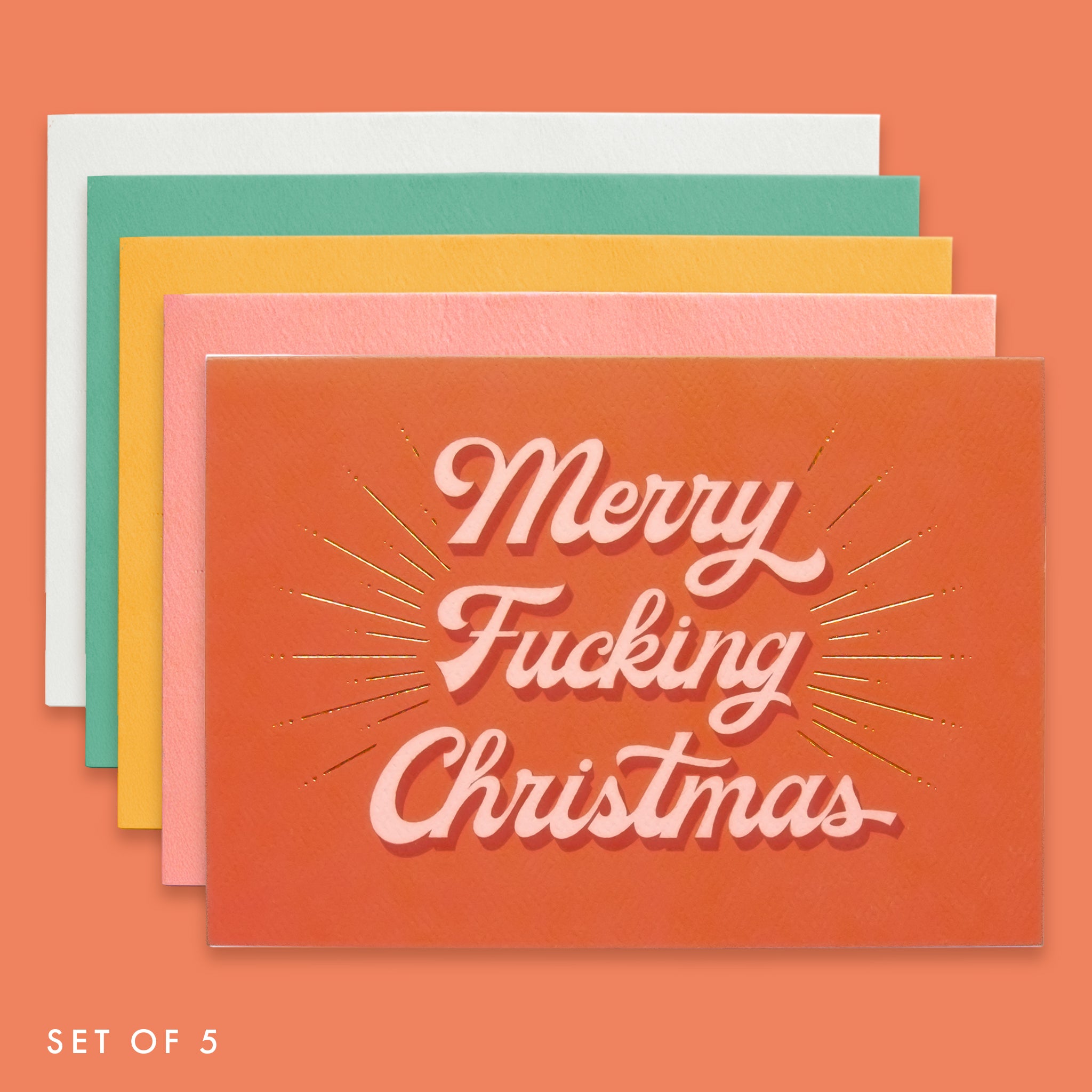 A pack of five holiday greeting cards in a variety of colors including, green, rust, salmon, orange and ivory. The front of each card reads, "Merry Fucking Christmas".