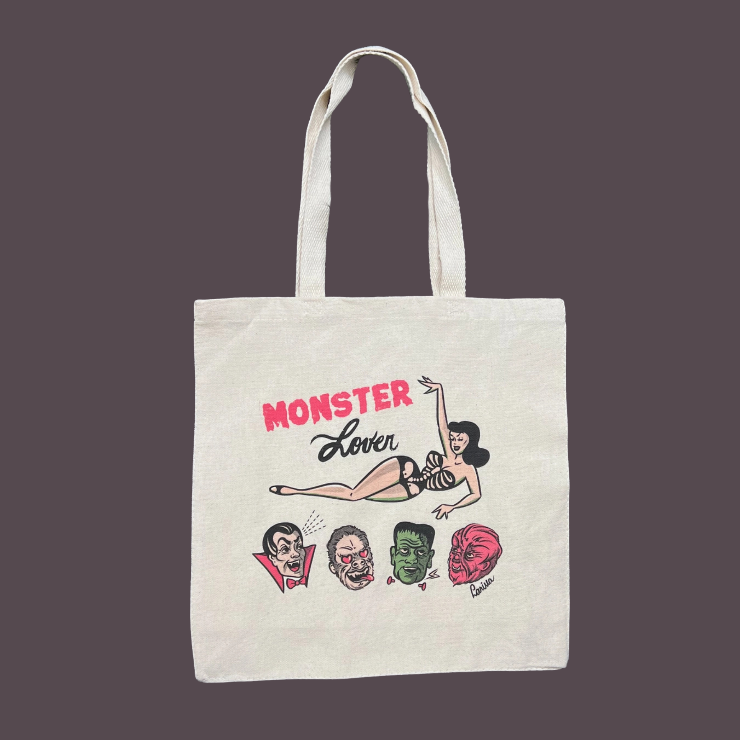 a canvas tote bag with a design and "monster lover" printed.