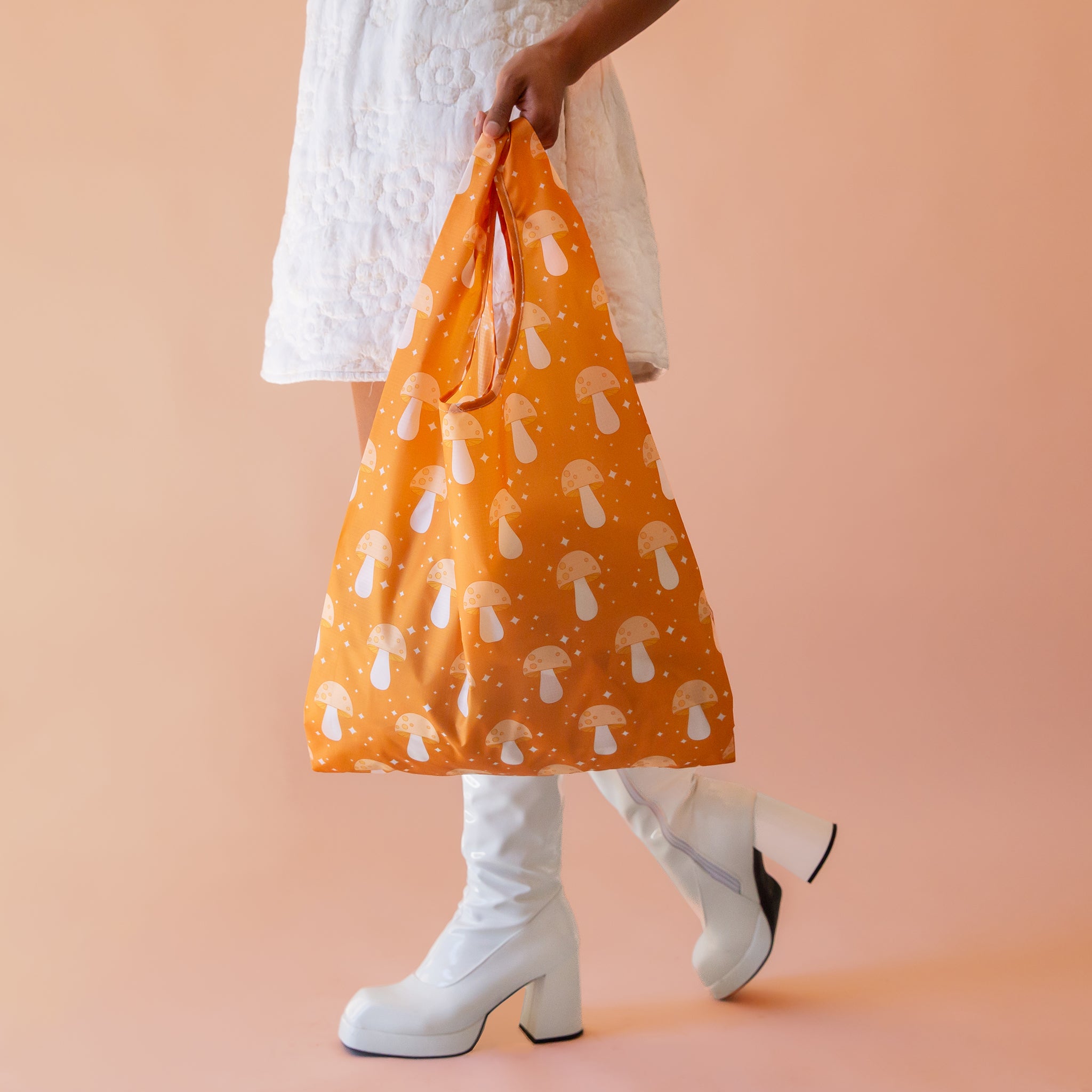 An orange nylon bag with a mushroom and twinkle star print.