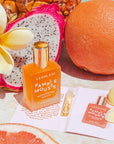 A bottle of orange aromatherapy essence with a gold lid that reads, 'Leahlani Pamplemouse Aromatherapy Essence'. 