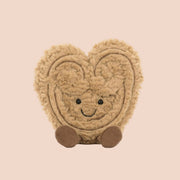 A brown stuffed toy with a smiling face and brown legs and feet. 