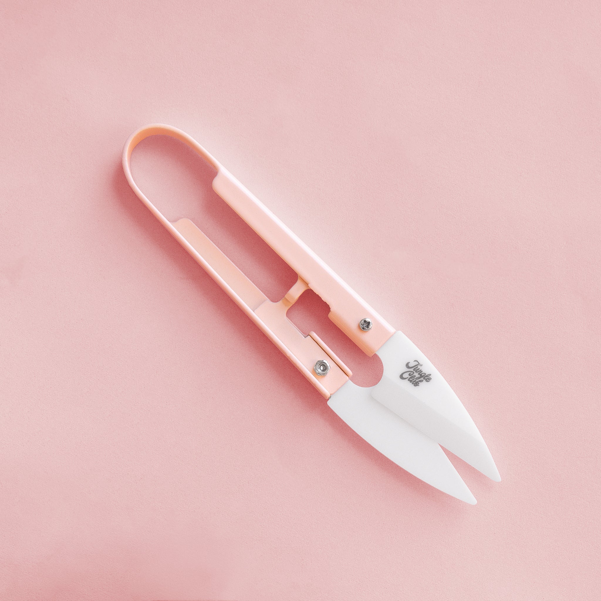 On a pink background is a pair of pink mini plant shears with small text on the clippers that reads, "Jungle Club".