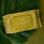 Green package of cleansing wipes with white leaf detailing is shown against a green background. 