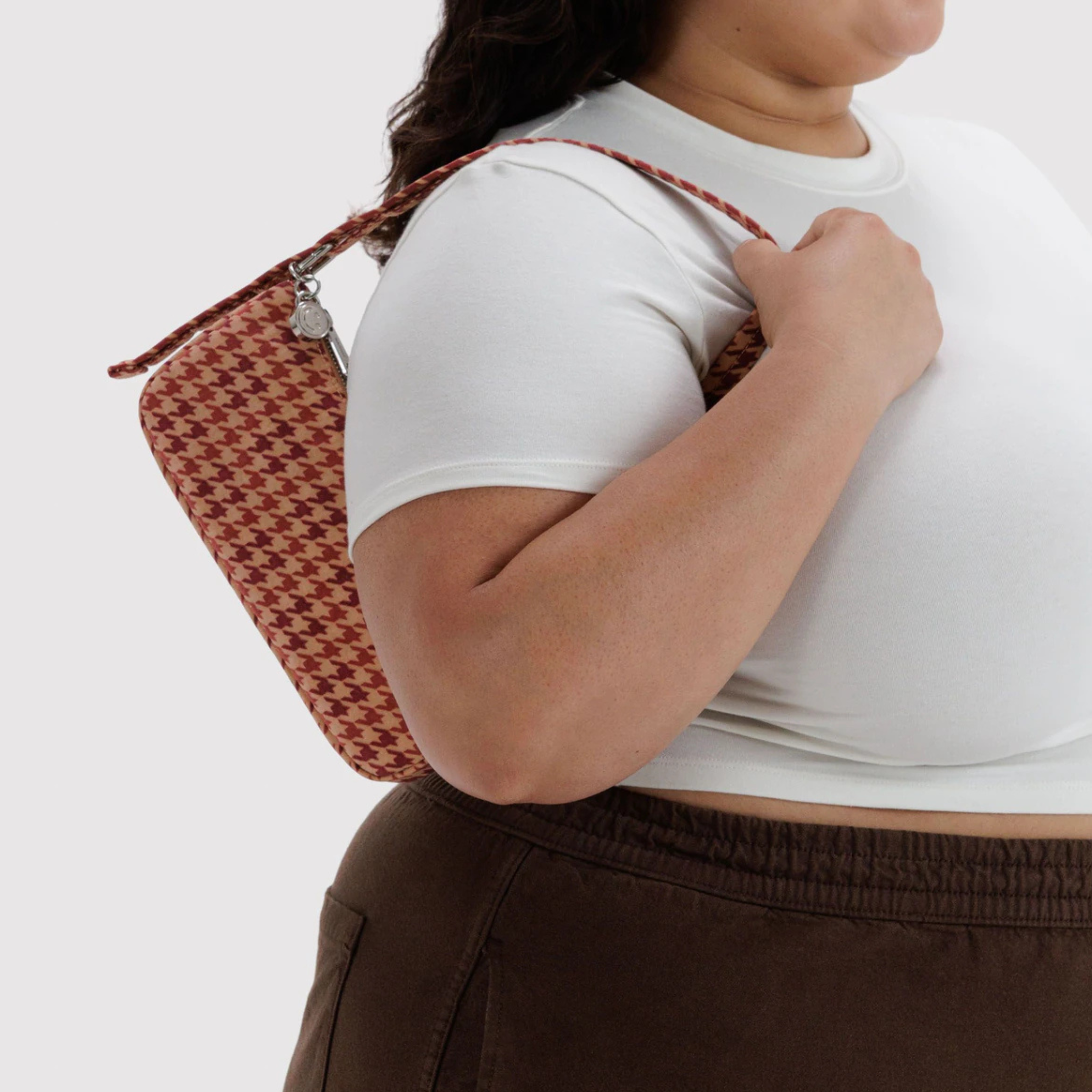 A tan and dark pinkish red patterned shoulder bag.