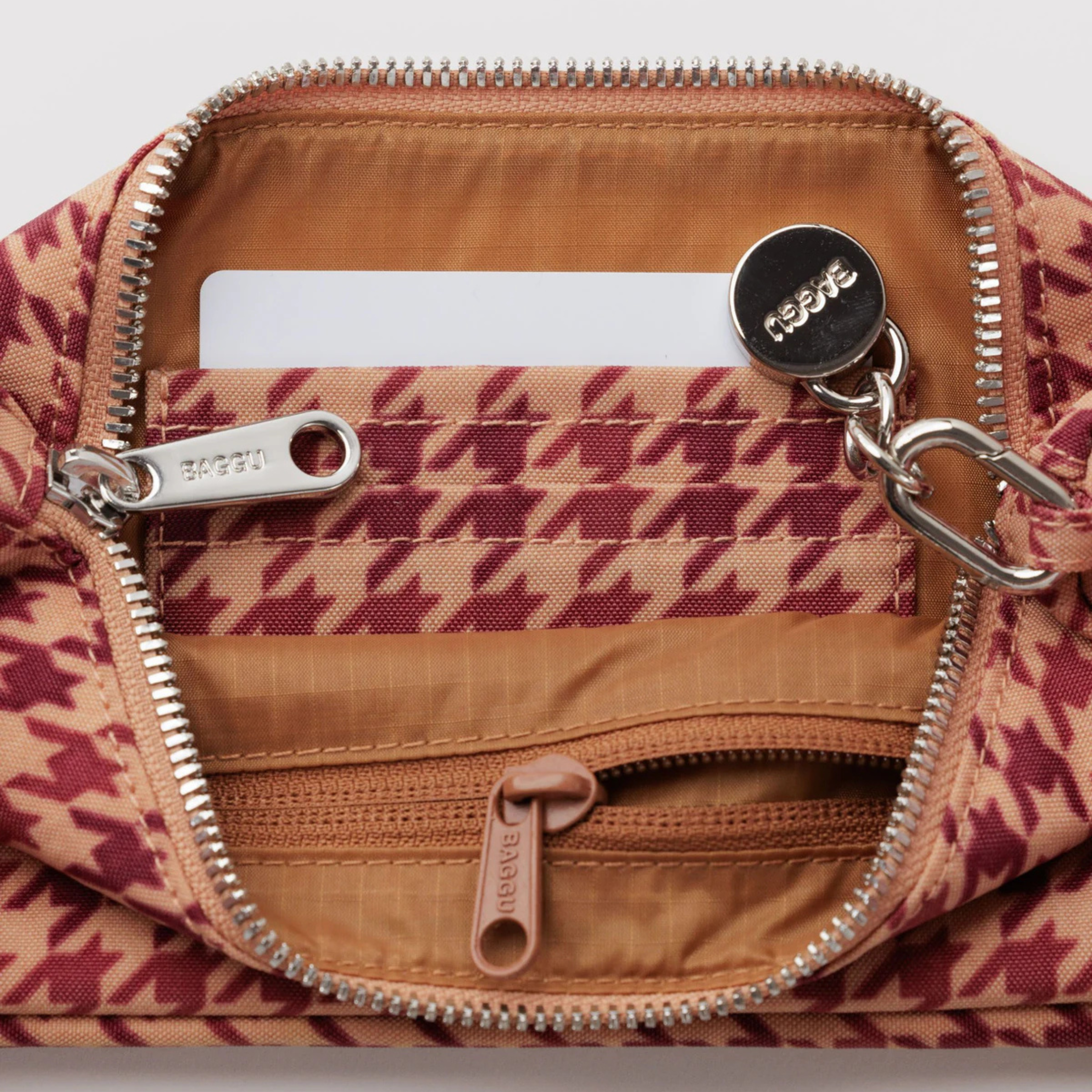A tan and dark pinkish red patterned shoulder bag.
