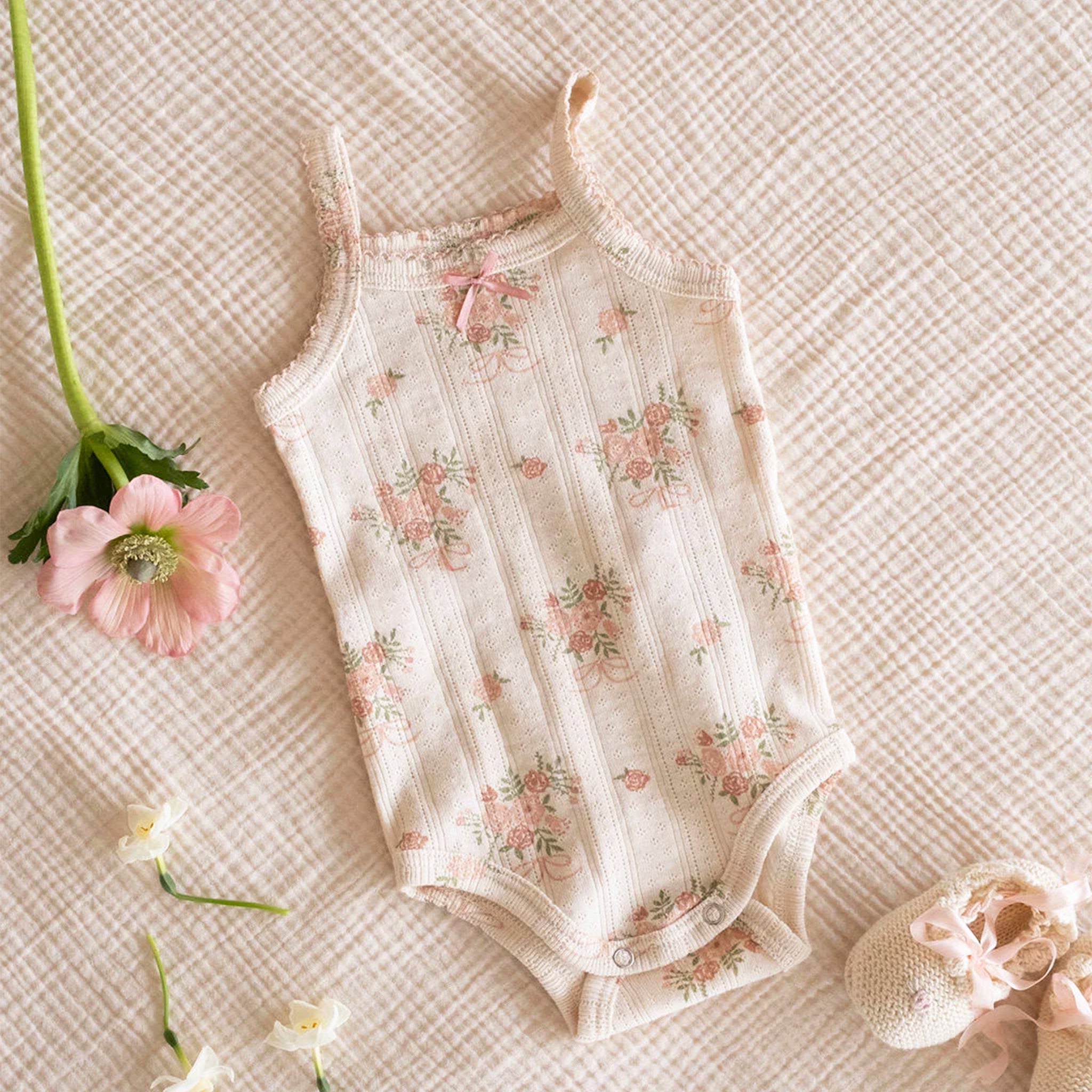 A neutral tank top onesie with a floral print. 