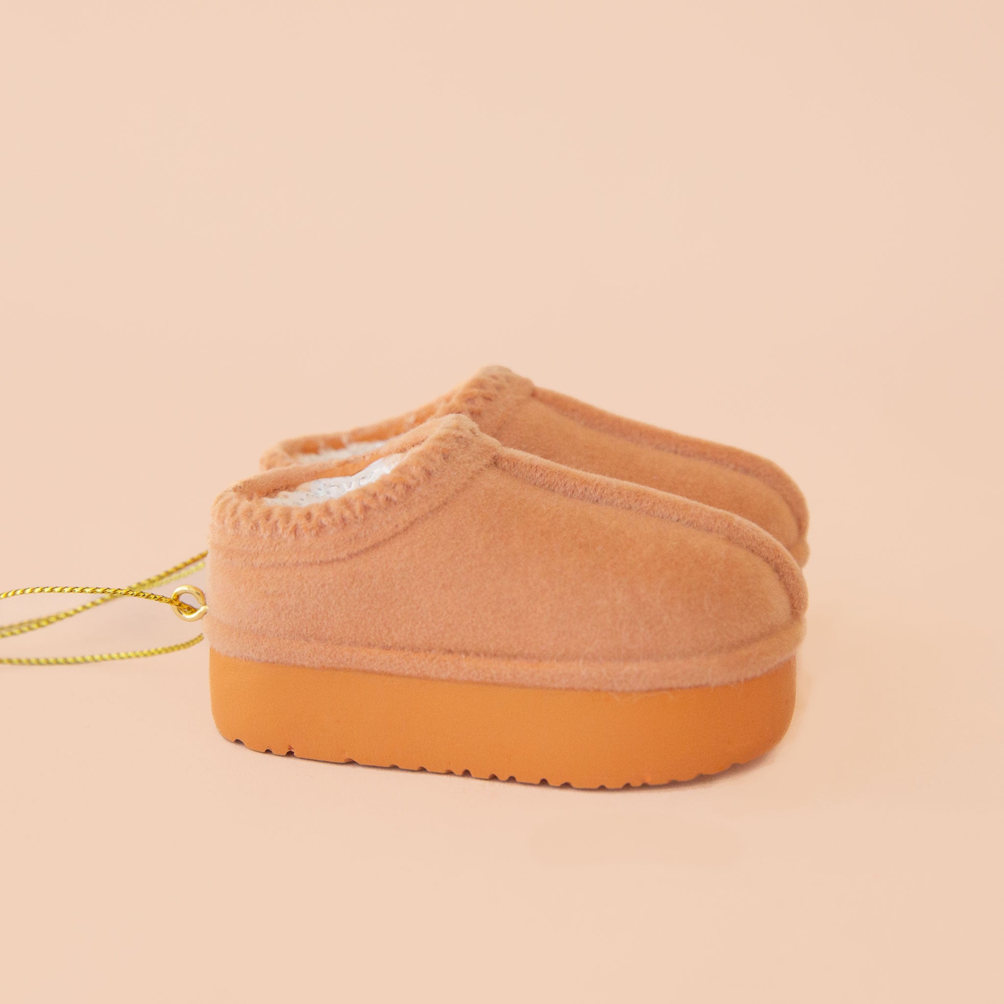 A tan pair of UGG inspired slipper shaped ornament. 