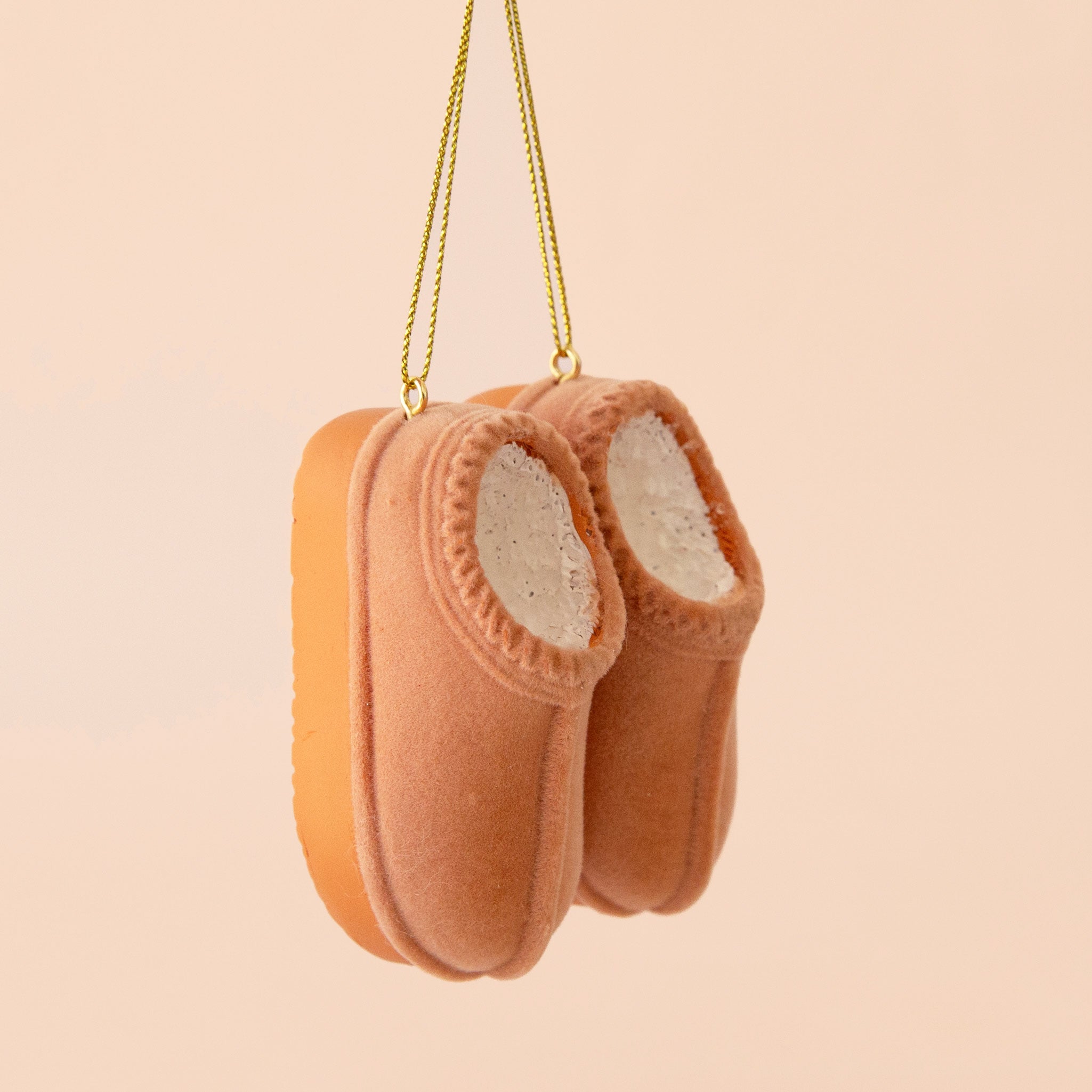 A tan pair of UGG inspired slipper shaped ornament. 