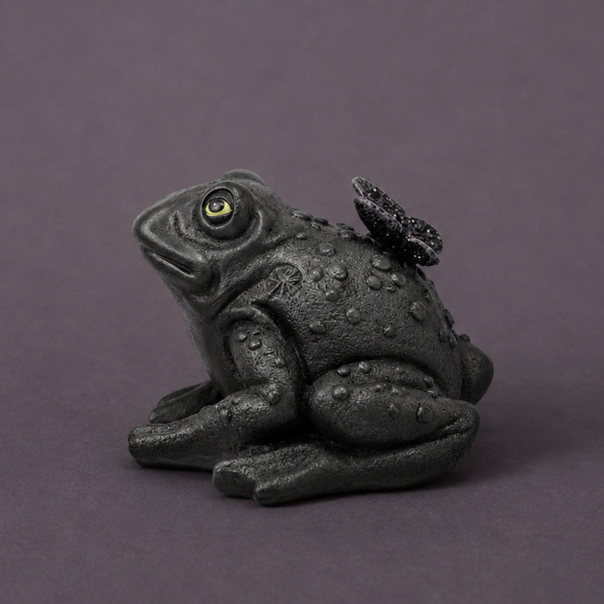 a toad shaped piece of decor with a butterfly on its back