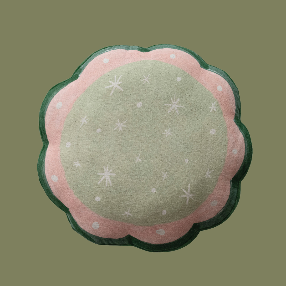 a round scalloped pillow with a christmas tree embroidered on the front and snowflake designs on the back. 
