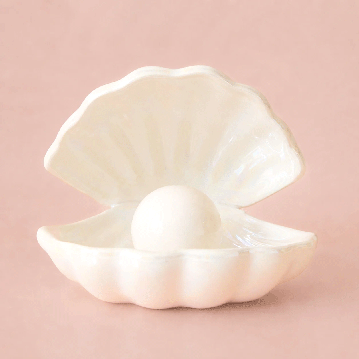 A GIF of a white ceramic shell shaped night light flashing off and on.