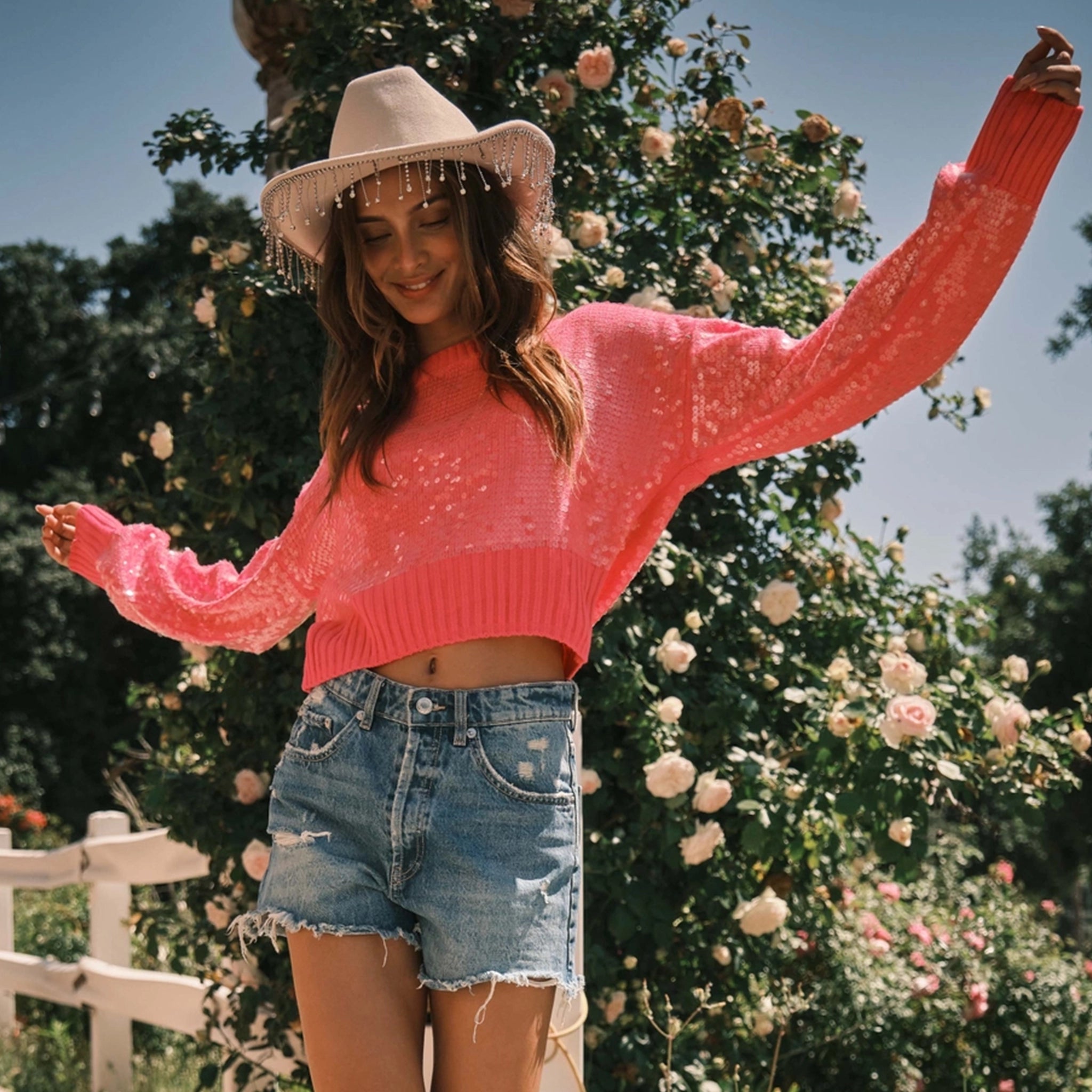 A model wearing a pink sequin cropped sweater.