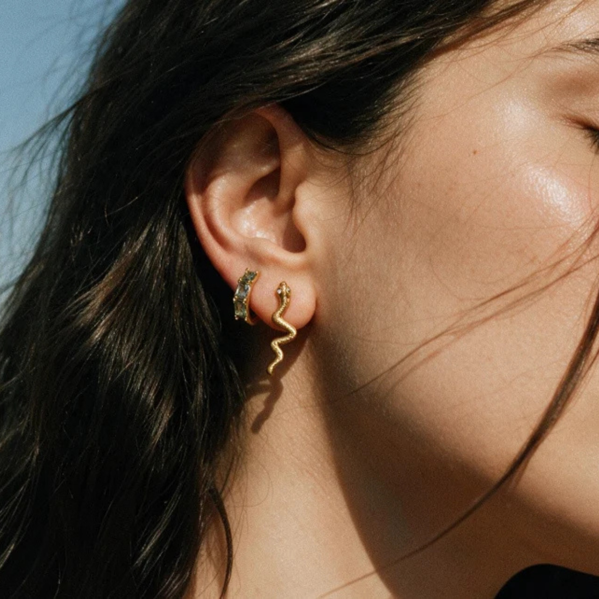 a pair of gold snake shaped earrings. 