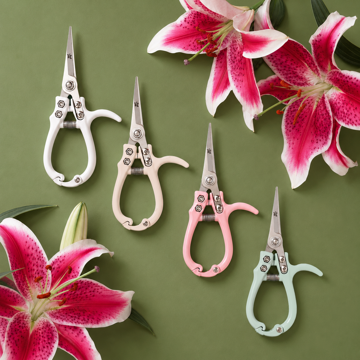 Four pruning shears on a green gorund with beautiful lillies surrounding them.