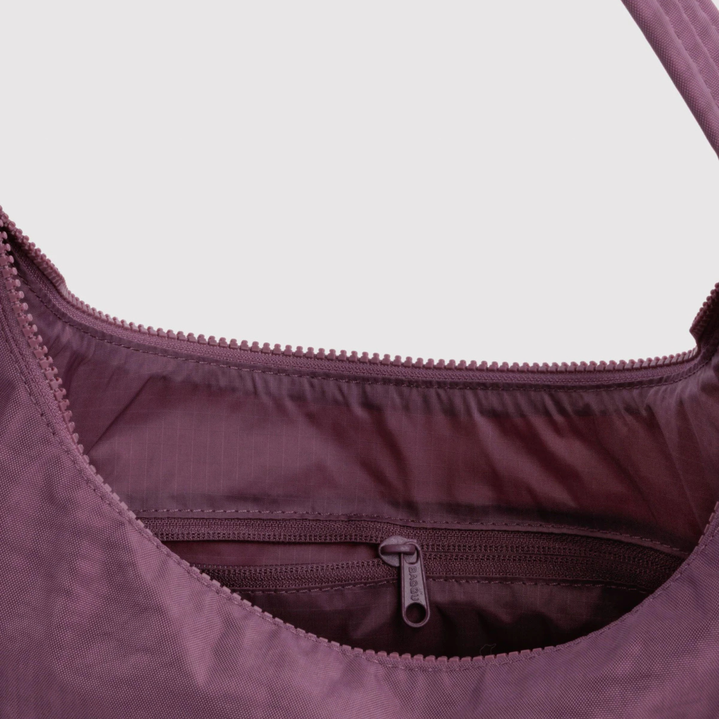 A plum purple colored nylon shoulder bag.