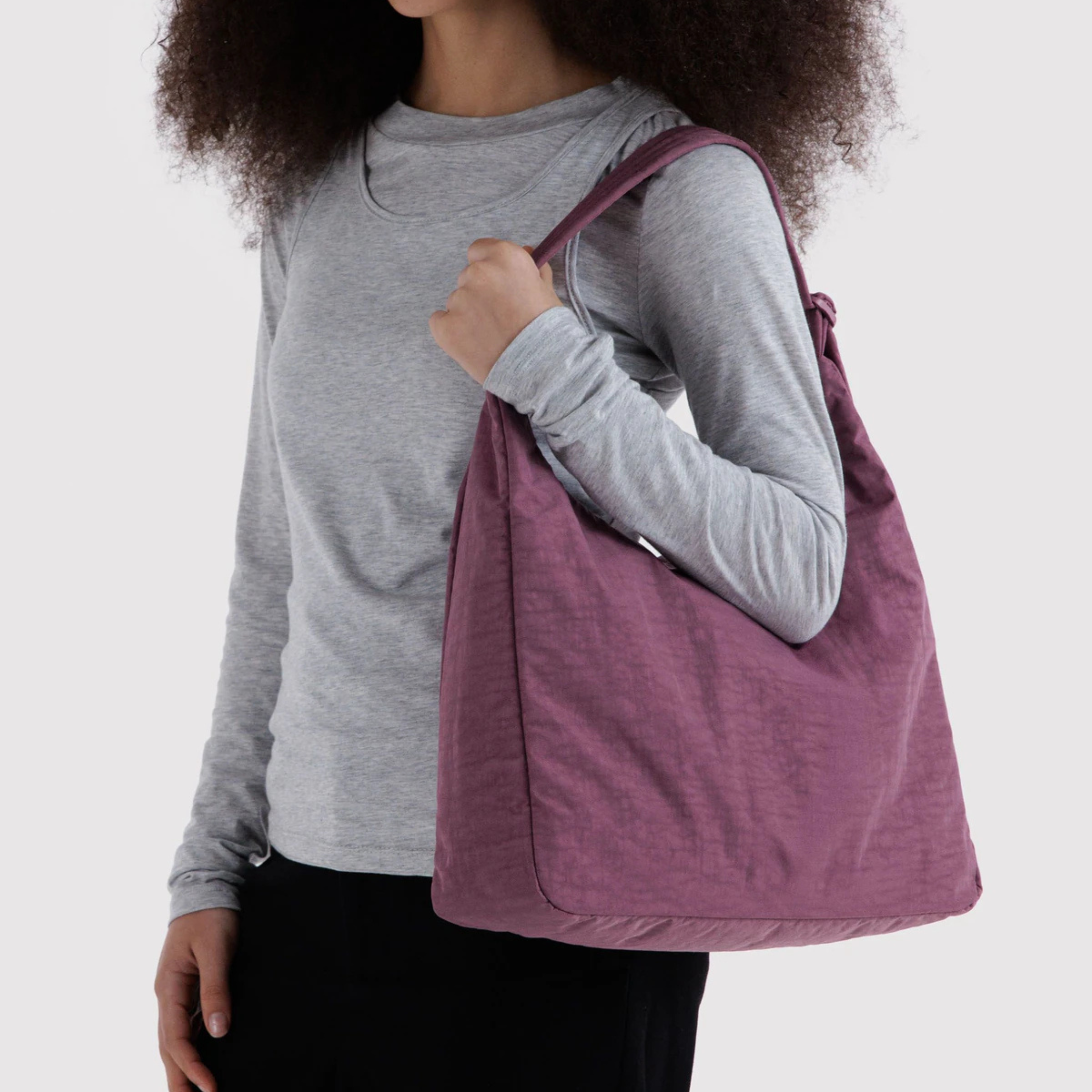 A plum purple colored nylon shoulder bag.