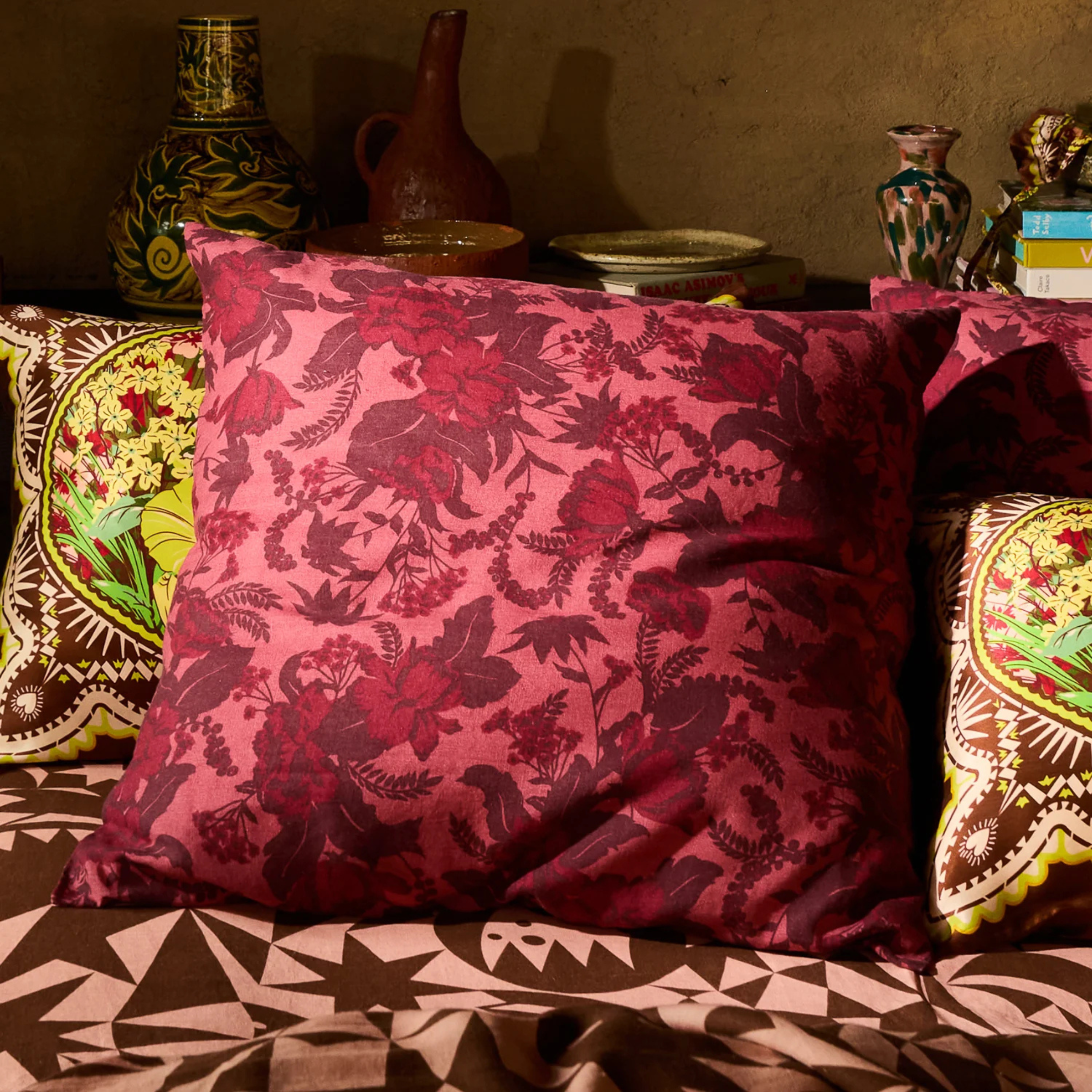 a burgundy and pink floral printed pillow
