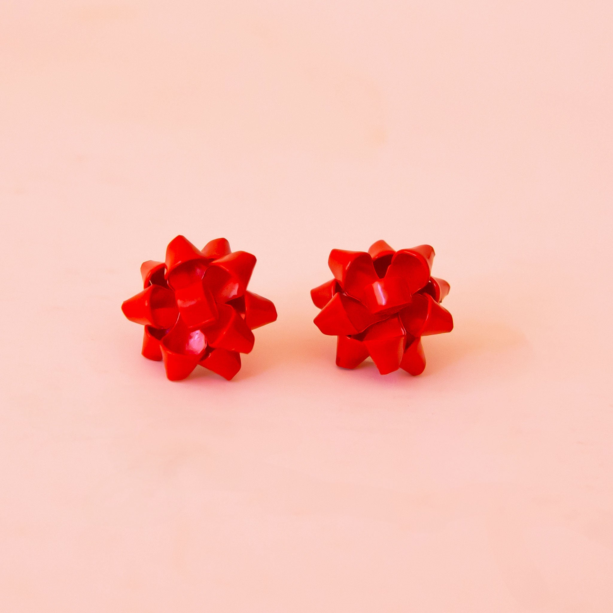 A red pair of bow shaped earrings