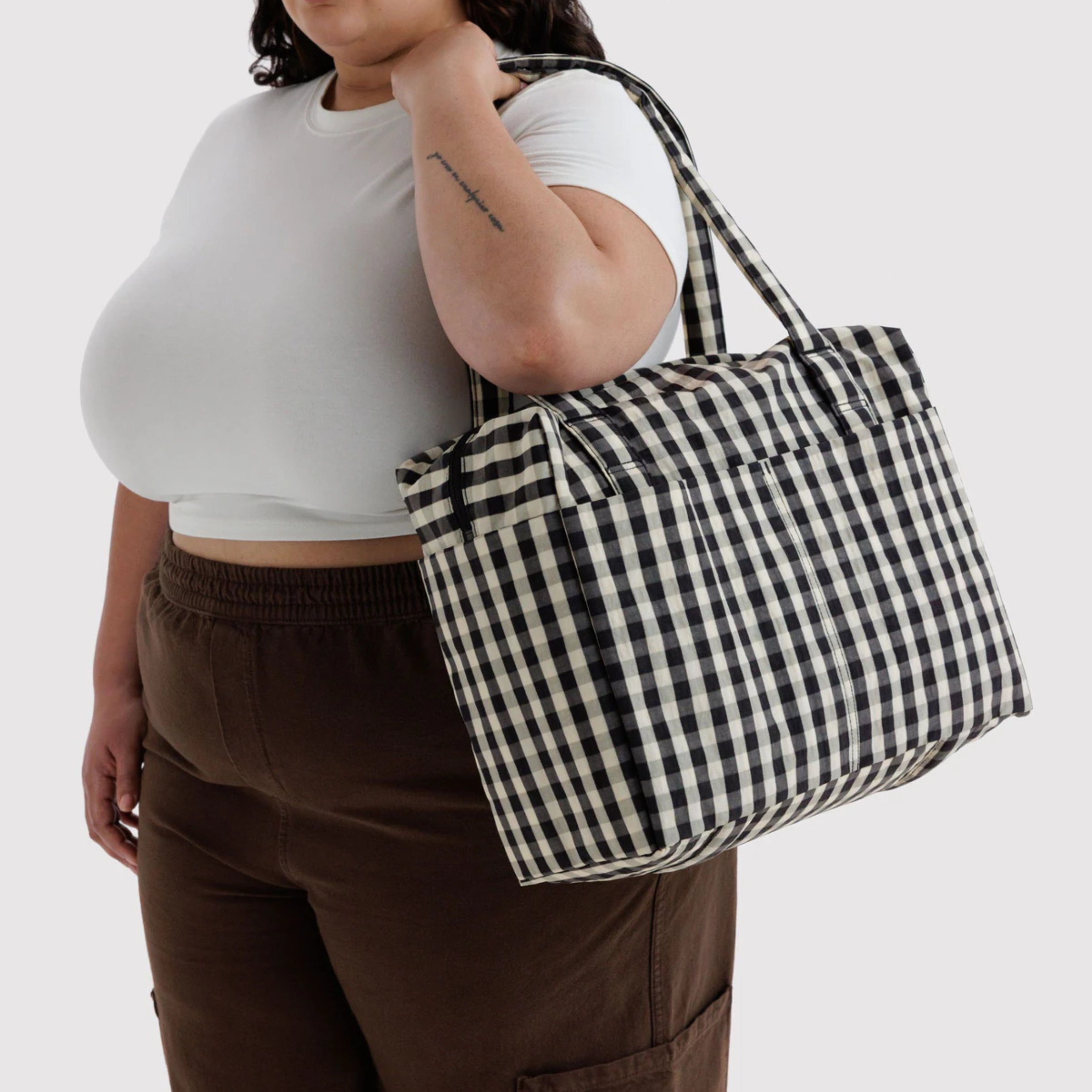 A black and cream gingham print nylon carry on bag.