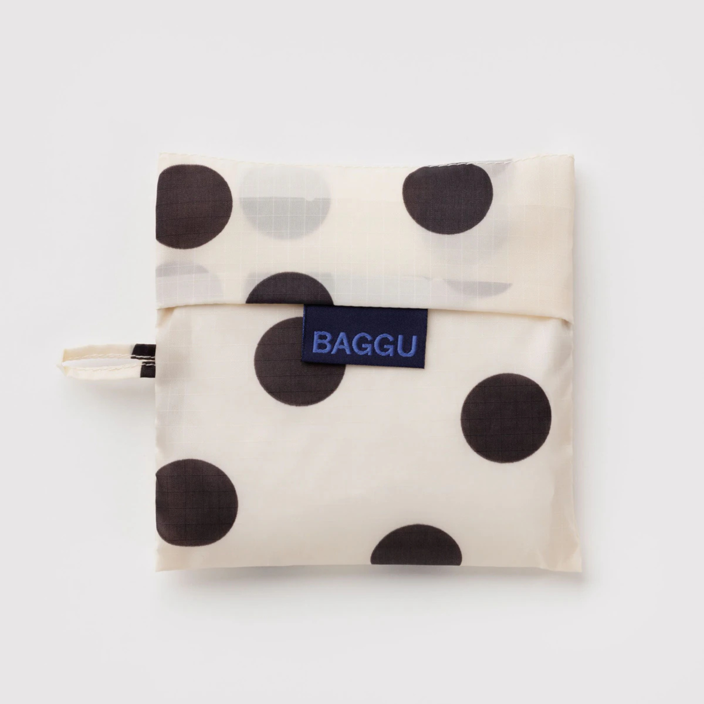 A cream and black polka dot nylon tote.