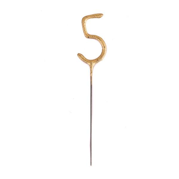 On a white background is a gold sparkling candle in the shape of the number five.