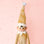A gold sparkle elf shaped ornament with long limbs. 
