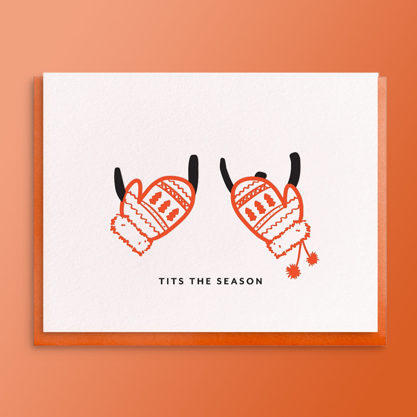 Greeting Card with a line drawing of boobs covered with holiday knit mittens. The text on the card reads "Tits the Season". The card is laying on a warm red background. 
