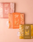 A bundle of three reusable nylon tote bags with different plant patterns on them. 