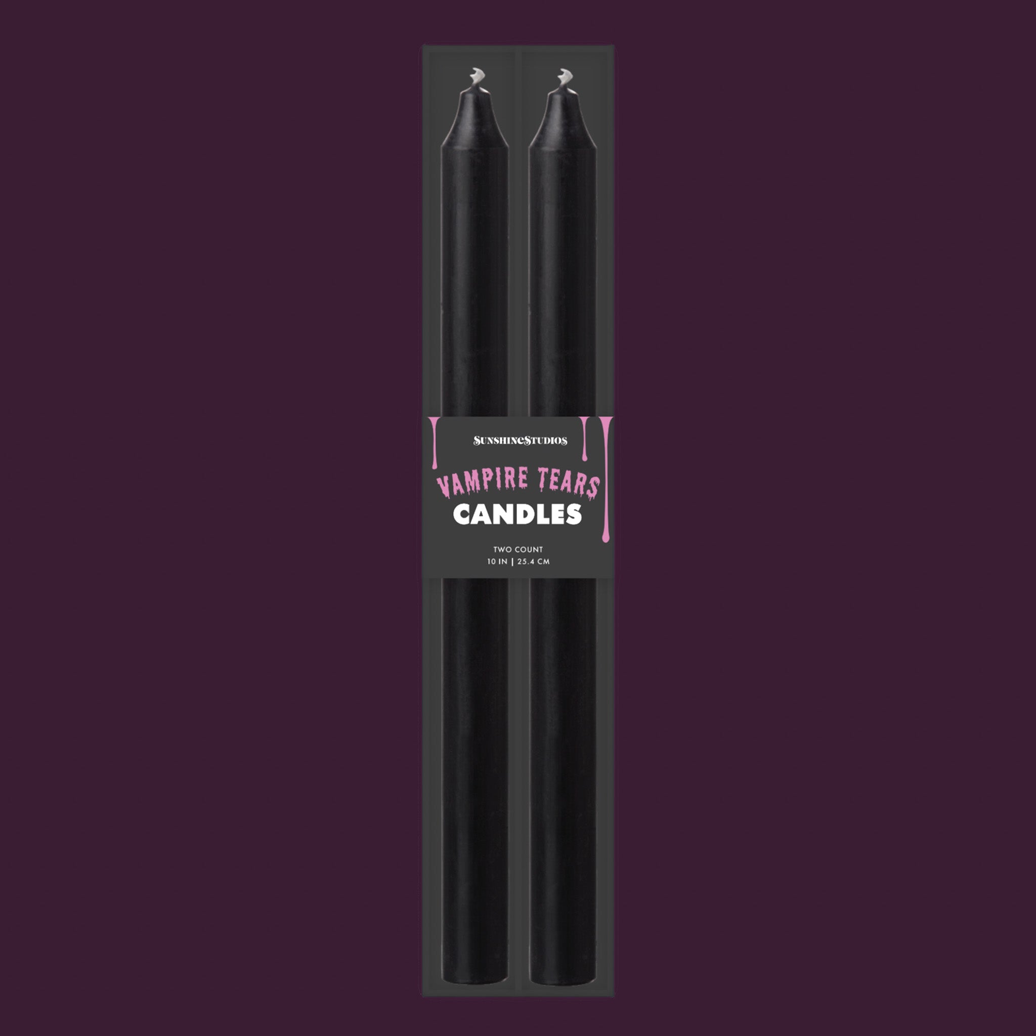 Two black taper candles in a black retail package with a label reading 'Vampire Tears Candles' on a dark purple background.