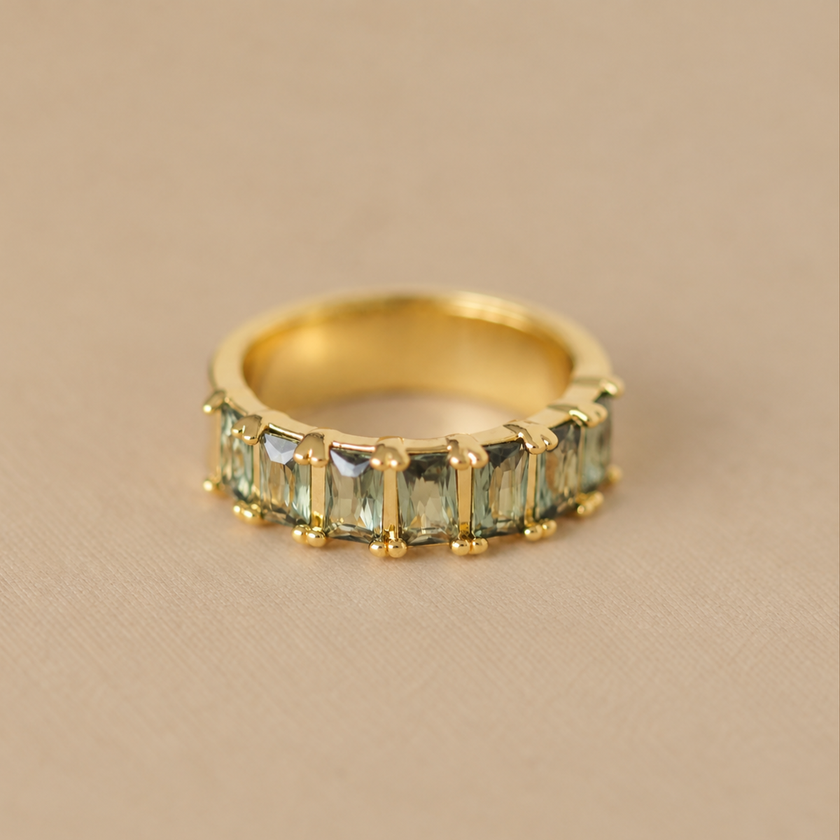 a gold ring with greens tones across the top.