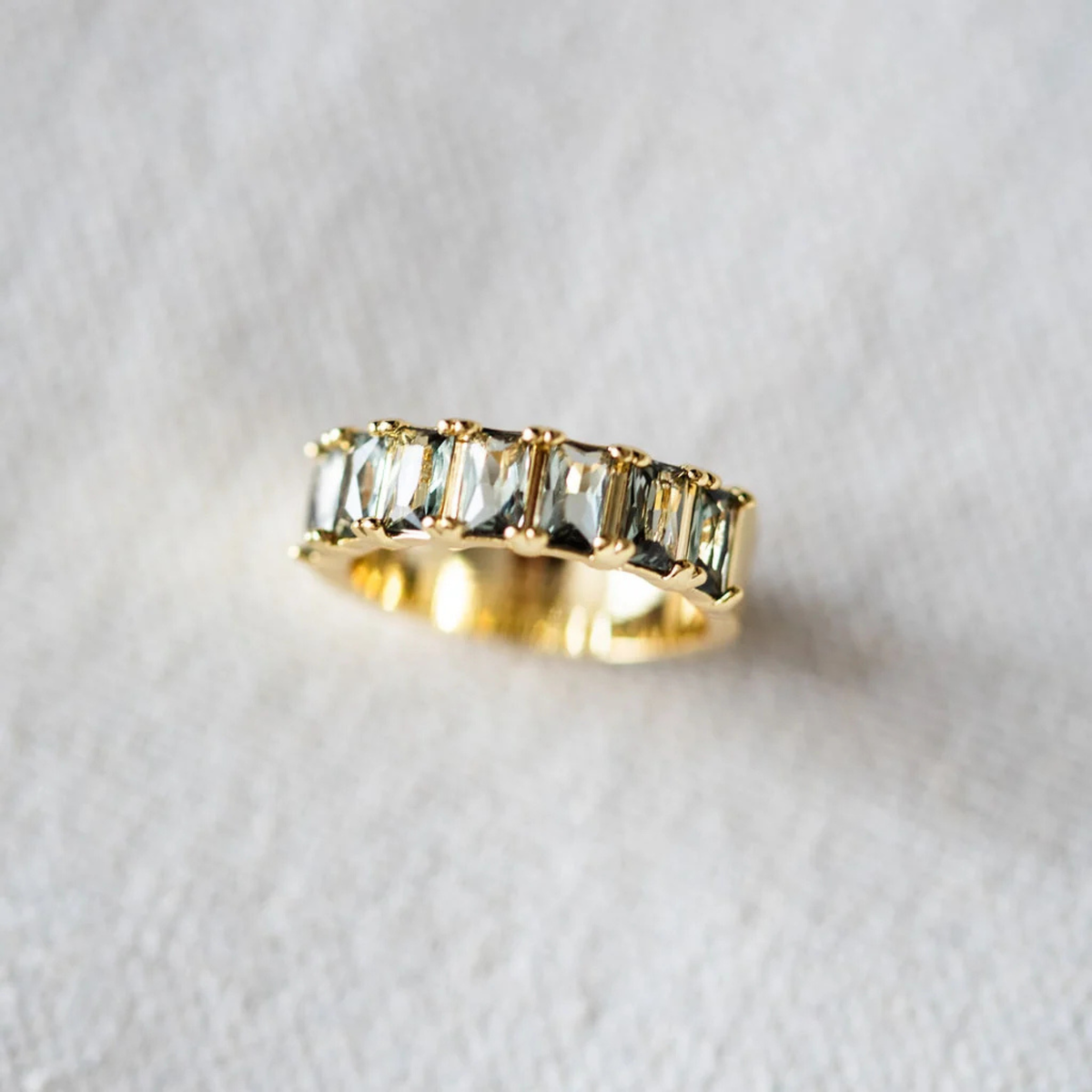 a gold ring with greens tones across the top.