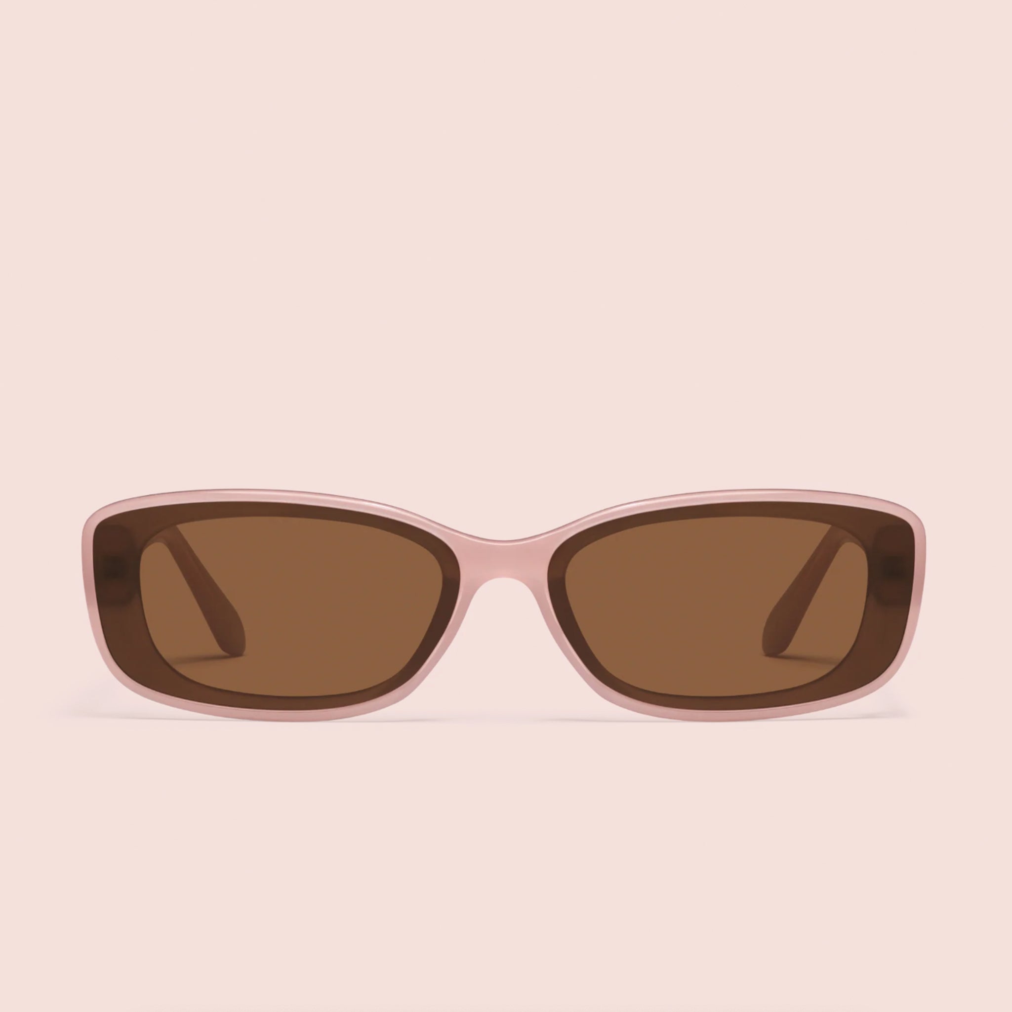 A pair of pink framed sunglasses with a brown lens. 