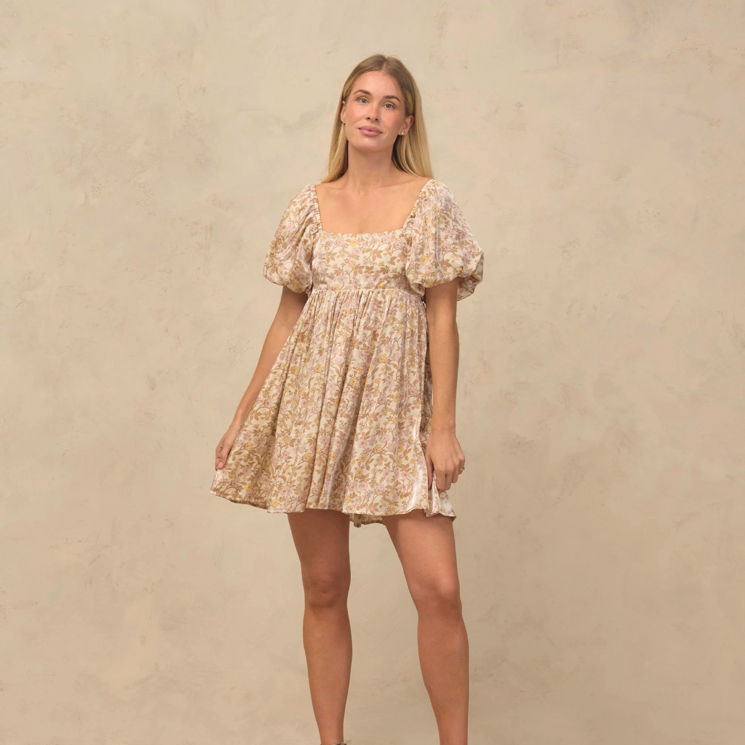 a neutral floral patterned mini dress with puff short sleeves. 