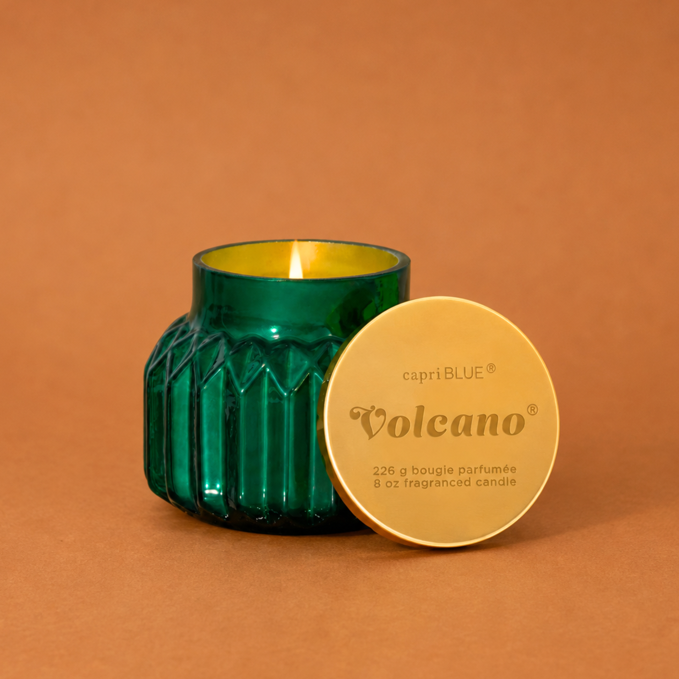 green glass jarred candles with a gold lid. 